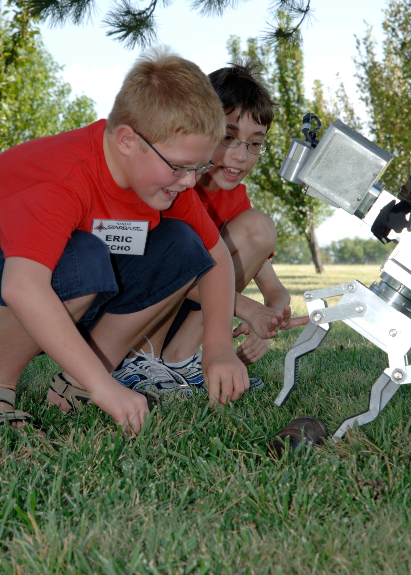 Kansas Starbase summer program students Eric Flett, 10, and Alex Blonigen, 12, use the Explosive Ordinance Disposal's HD1 robot to pick up a simulated bomb during their visit to the 22nd Civil Engineer Squadron’s Explosive Ordinance Disposal flight Aug 8. The Kansas Starbase goal is to improve students in the fourth, fifth and sixth grades interest in the areas of math, science and technology as well as instilling a sense of pride and personal accomplishment.  The Air Force National Guard runs the Wichita area Kansas Starbase program with several different classes held throughout the school year and summer. (photo by Airman 1st Class Roy Lynch) 