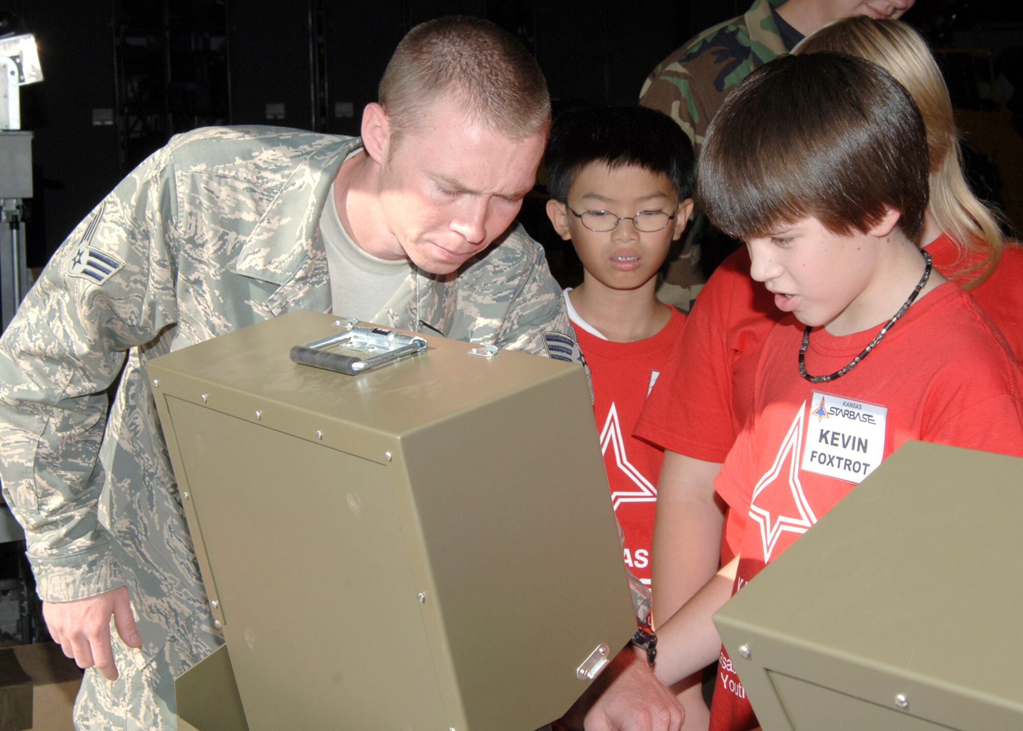 MCCONNELL AIR FORCE BASE, Kan. – Senior Airman Steven Mabe from the 22nd Civil Engineer Squadron’s Explosive Ordinance Disposal instructs local students from various schools enrolled in the Kansas Starbase summer program on how to operate the Explosive Ordinance Disposal's control unit Aug 8. The Kansas Starbase goal is to improve students in the fourth, fifth and sixth grades interest in the areas of math, science and technology as well as instilling a sense of pride and personal accomplishment.  The Air Force National Guard runs the Wichita area Kansas Starbase program with several different classes held throughout the school year and summer. (photo by Airman 1st Class Roy Lynch) 
