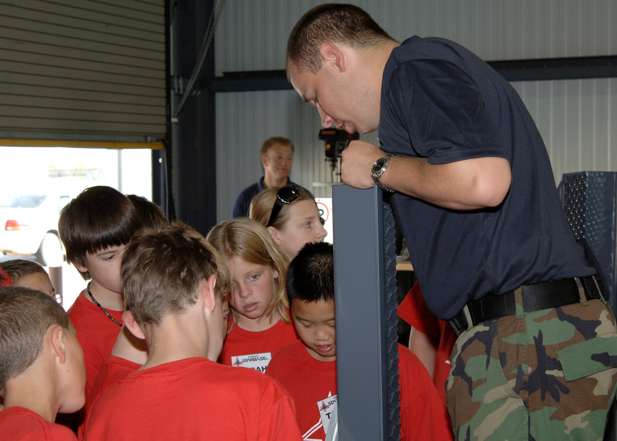MCCONNELL AIR FORCE BASE, Kan. – Airman 1st Class Adam Lance, 22nd Civil Engineer Squadron Explosive Ordinance Disposal, instructs local students from various schools enrolled in the Kansas Starbase summer program on explosive ordinance disposal signs Aug 8. The Kansas Starbase goal is to improve students in the fourth, fifth and sixth grades interest in the areas of math, science and technology as well as instilling a sense of pride and personal accomplishment.  The Air Force National Guard runs the Wichita area Kansas Starbase program with several different classes held throughout the school year and summer. (photo by Airman 1st Class Roy Lynch)