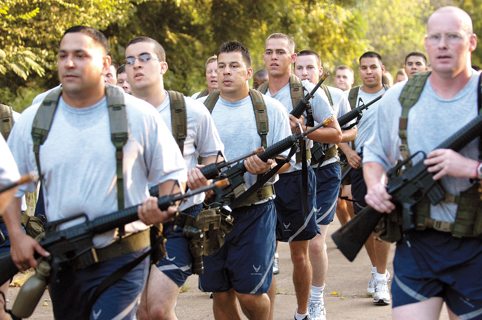 Combat Readiness School Commandant Master Sgt. Brian Kaut, far right, leads 40 Airmen on a run through the overgrown streets of Glenwood Training Area on the first day of the three-week course at Tinker Air Force Base. Students are early warned to expect the unexpected here, lessons the cadre say will help them survive in combat areas. (Air Force photo by Margo Wright)