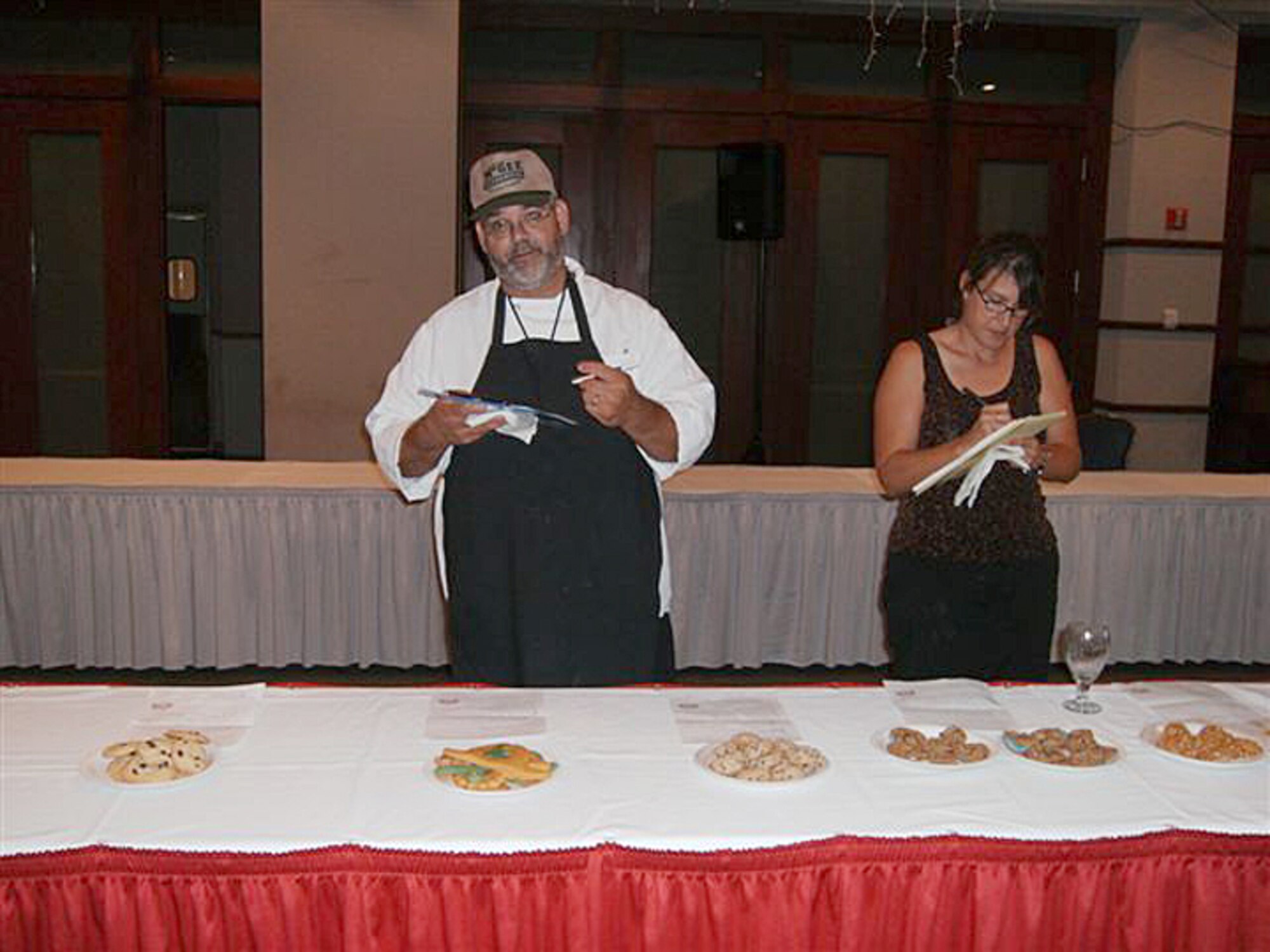 MCCONNELL AIR FORCE BASE, Kan. -- Alan McGee, Club McConnell head chef, and Stacy Mayou, 22nd Services Squadron Marketing Director judge cookies submitted into the Colossal Cookie Contest Aug. 9 at the Robert J. Dole Center. The contest was hosted by the 22nd Services Squadron and had 18 entries. Contestants’ entries were judged on taste, appearance and creativity. (photo by Amanda Pozehl)