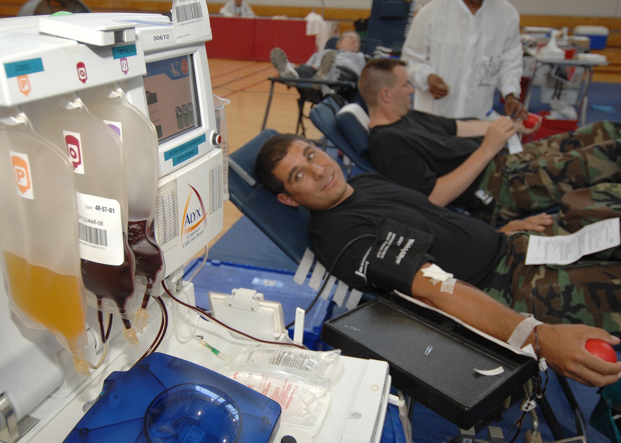Technical Sgt. Carlos Tapia from the 61st Communications Squadron, Los Angles Air Force Base, CA, watches his blood being pumped to the ALYX, a blood storing and withdrawal machine, at the same time being replenished with protein, during a base wide blood drive Aug 15, 2007. (Photo by Stephen Schester)
