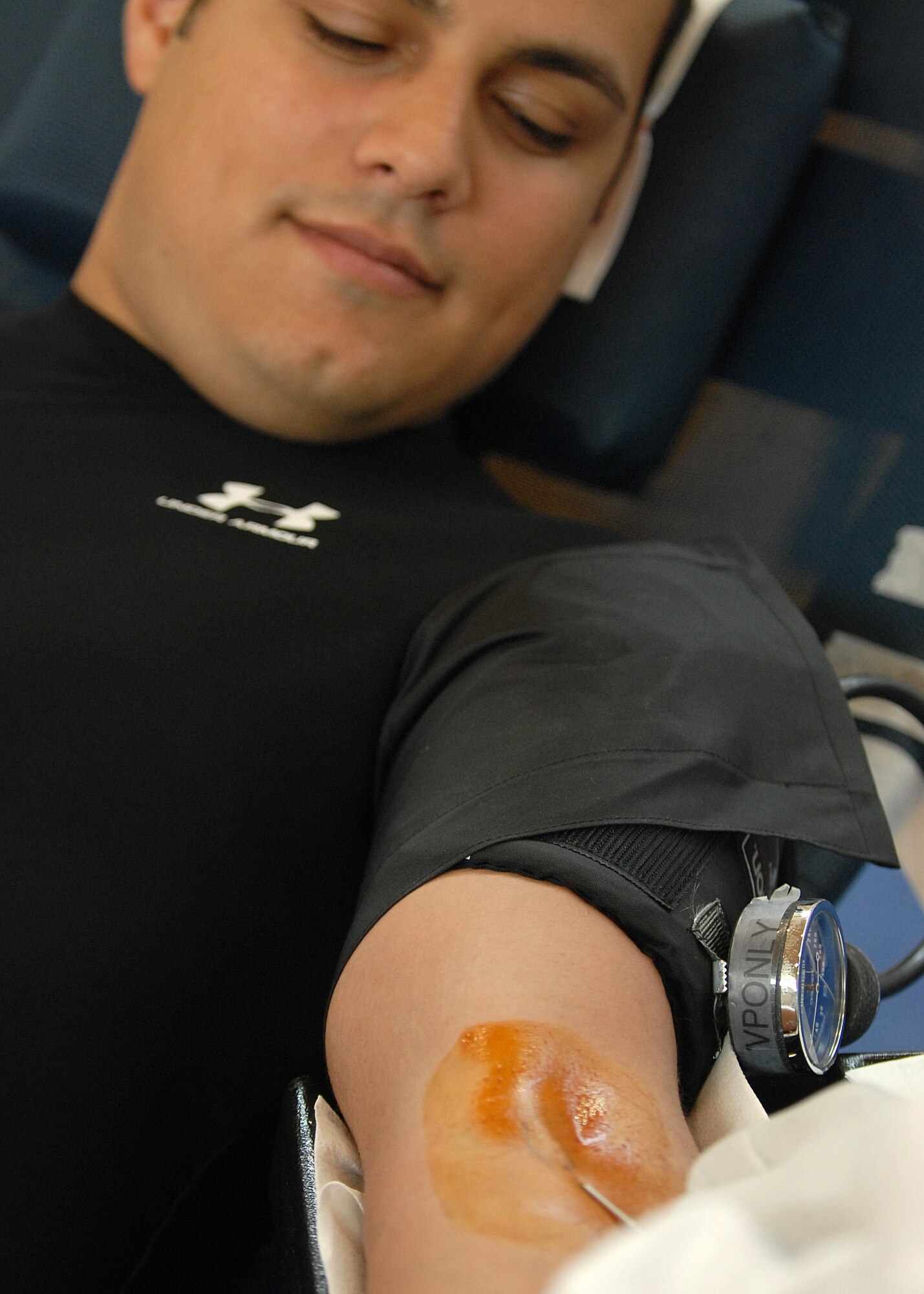 First Lieutenant Pedro Velez, from the Launch Range and Space Wing at the Space and Missile Center, Los Angeles Air Force Base, CA, observes the needle being inserted into his left arm during a base wide blood drive on Aug .15, 2007. (Photo by Stephen Schester)
