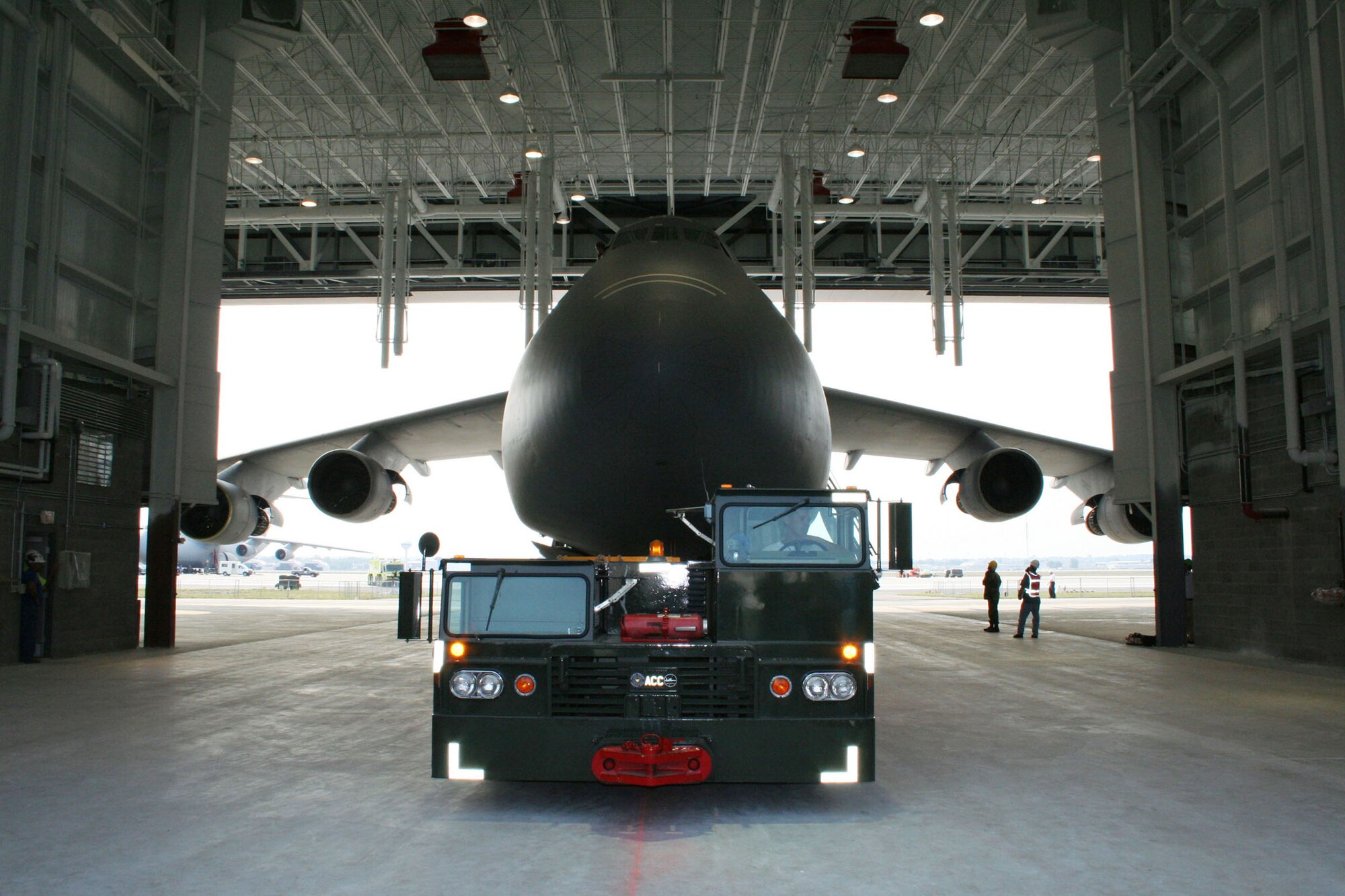 WRIGHT-PATTERSON AFB, Ohio - A tow truck pulls a 445th Airlift Wing C-5 Galaxy into the new Fuel System Maintenance Hangar August 15, 2007, to ensure the aircraft fits inside the new hangar appropriately . The hangar is a tail-out, high bay fuel cell maintenance hangar.  It includes two 14 foot tall adjacent spaces for auxiliary functions, which include administrative and supervisory functions, a tool room, and space to house mechanical, electrical, and fire protection equipment. (U.S. Air Force photo/Mary Allen)