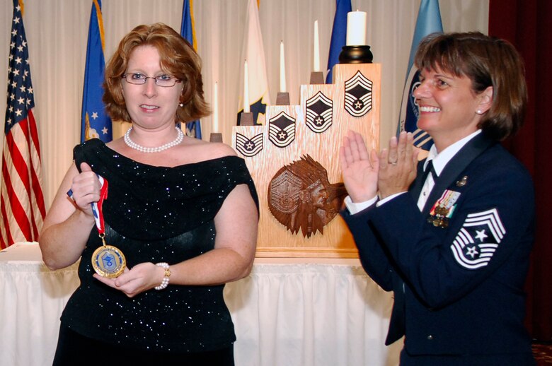 HANSCOM AFB, Mass. -- Jerrilyn Rinaldi, the great niece of retired Chief Master Sgt. Esther MacKay, accepts a medallion presented by Chief Sirois on behalf of Chief MacKay from the Charter Chiefs Group. Chief MacKay was appointed an honorary Charter Chief during the Chief’s Recognition Ceremony. At 102, Chief MacKay is the oldest Air Force chief master sergeant and is only the third woman to be appointed an honorary Charter Chief. (U.S. Air Force photo by Mark Wyatt)
