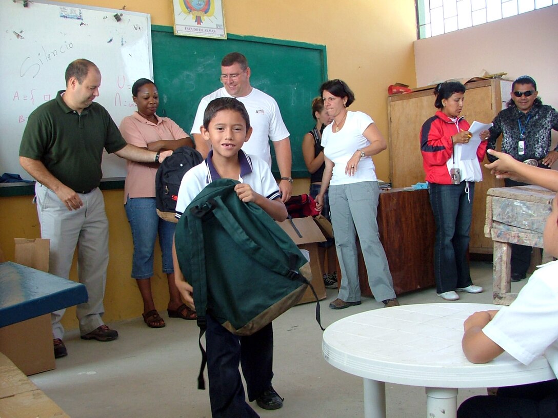 Airmen from Forward Operating Location Manta in Ecuador hand out backpacks Jul. 26 at Jose Peralta School as part of "Give a Kid a Backpack" day.  (U.S. Air Force photo/2nd Lt. Naomi Evangelista)