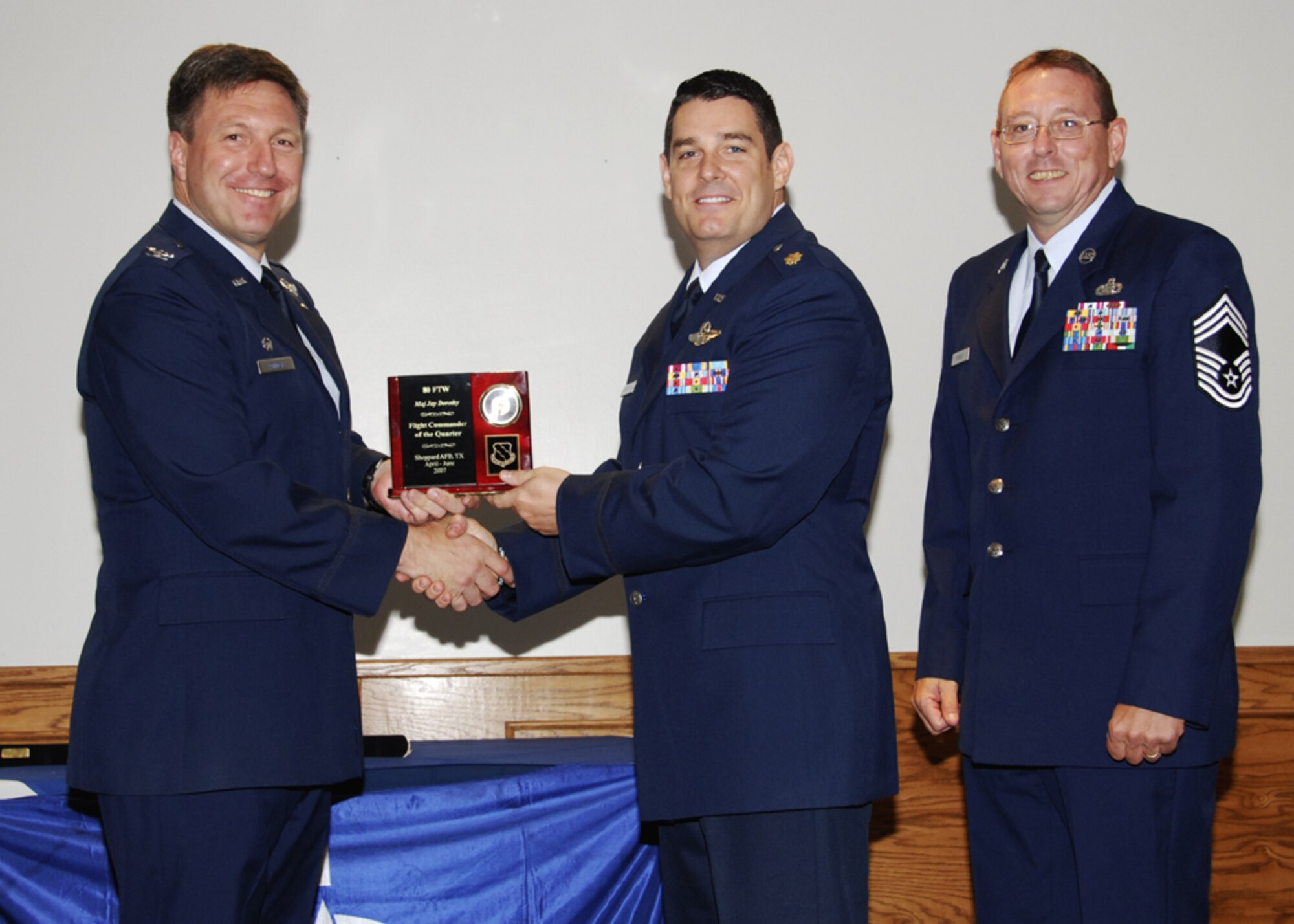 Maj. Jay Dorothy, 90th Flying Training Squadron, accepts the award for flight commander of the quarter at the 80th Flying Training Wing quarterly awards ceremony. (U.S. Air Force photo/Sandy Wassenmiller)