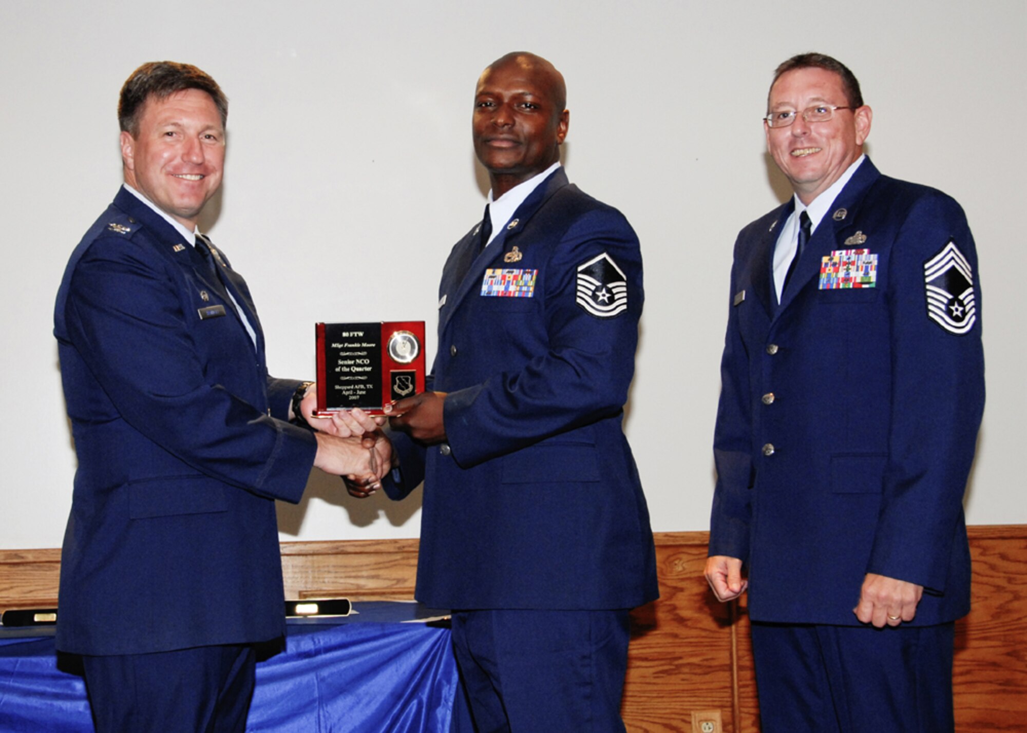 Master Sgt. Frankie Moore, 80th Flying Training Wing, accepts the award forsenior NCO of the quarter at the 80th FTW quarterly awards ceremony. (U.S. Air Force photo/Sandy Wassenmiller)