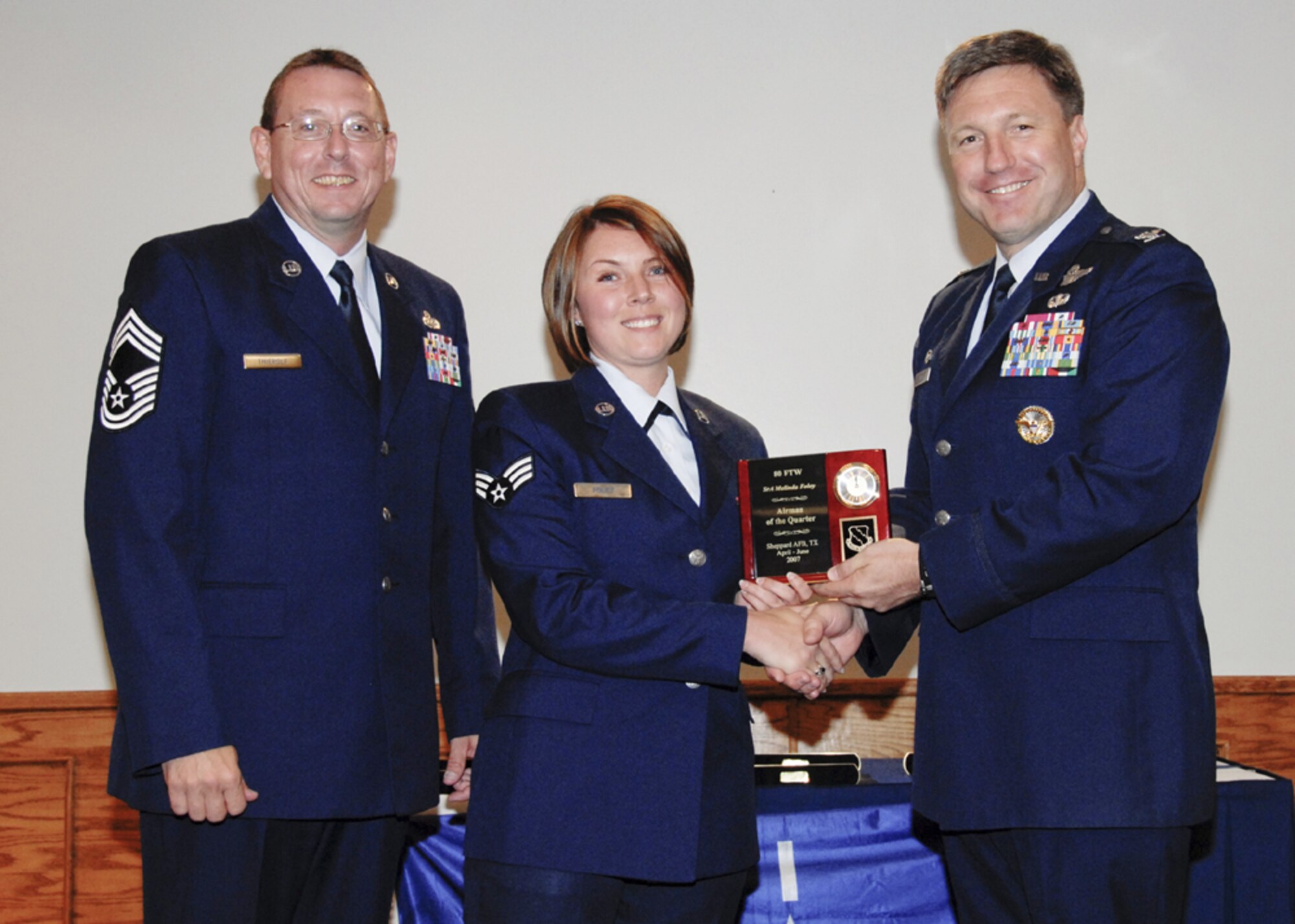 Senior Airman Melinda Foley, 80th Operations Support Squadron, accepts the award for Airman of the quarter at the 80th Flying Training Wing quarterly awards ceremony. (U.S. Air Force photo/Sandy Wassenmiller)