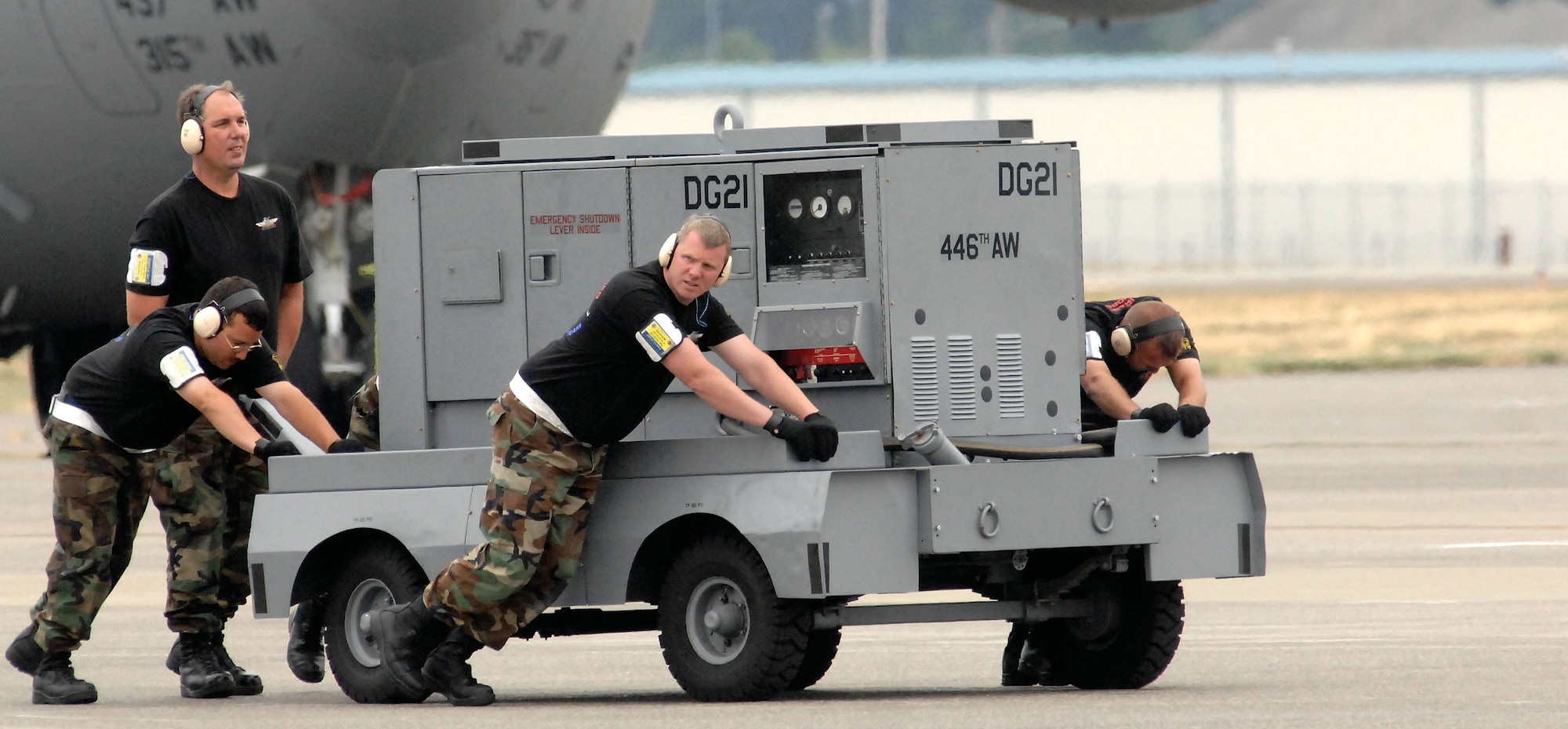 Members of the 446th Airlift Wing's Rodeo maintenance team, McChord Air Force Base, Wash.,  push a cart away from the C-17 during Rodeo 2007, held July 23-27 at McChord. (From left to right) Tech. Sgt. Michael Silva, Master Sgt. Michael Stewart, Tech. Sgt. Thomas Teal and Tech. Sgt. Thomas Timney. (U.S. Air Force photo/Abner Guzman)
