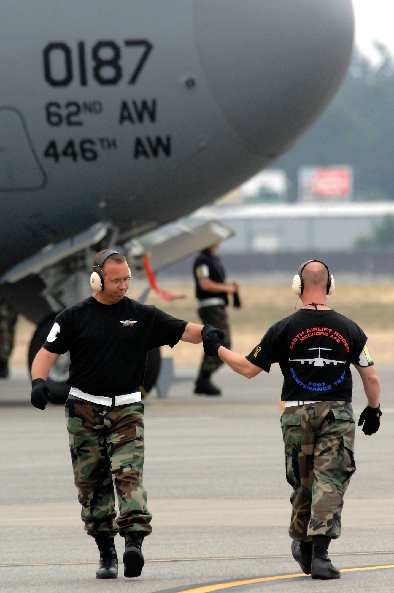 Reservists Tech. Sgt. Burke Stott, left, and Master. Sgt. Kevin Smith, 446th Airlift Wing maintenance team members from McChord Air Force Base, Wash., greet it other as they cross paths during Rodeo 2007, held July 23-27 at McChord. (U.S. Air Force photo/Abner Guzman)