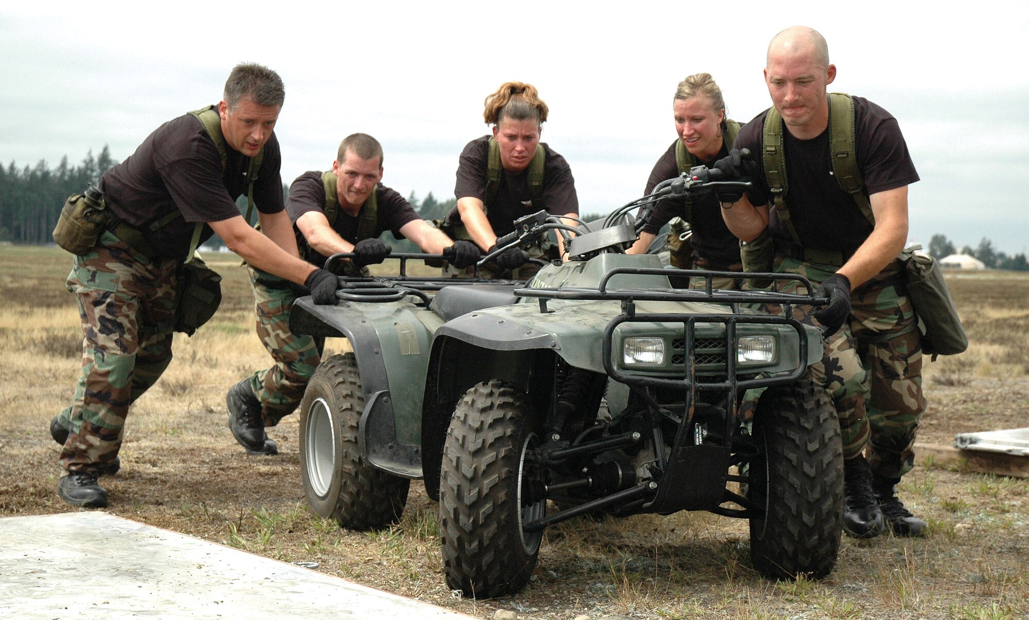 The 446th Airlift Wing's aerial port Rodeo team pushes a vehicle onto a pallet during one of the 15 skills tests they performed during the challenge course run at Rodeo 2007, McChord Air Force Base, Wash.  From left to right are Reservists Tech. Sgt. Bryan Henderson, Senior Airman Benjamin Thomsen, Master Sgt. Stephanie Place, Staff Sgt.Kathleen Myhre, and Tech Sgt. Josh Warbiany. (U.S. Air Force photo/Senior Airman Desiree Kiliz)