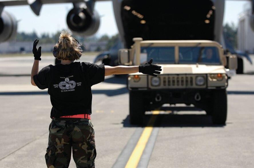 Reservist Staff Sgt. Kathy Myhre directs Master Sgt. Stephanie Place, as she off loads a Humvee from a C-17 Globemaster during the 446th Airlift Wing aerial port's Engine Running On Load competition for Air Mobility Rodeo 2007, July 25.  Rodeo 2007, hosted by Air Mobility Command, is a readiness competition of U.S. and international mobility air forces.  It focuses on improving warfighting capabilities and support of the Global War on Terrorism.  (U.S. Air Force Photo/Master Sgt. Richard Cassady)
