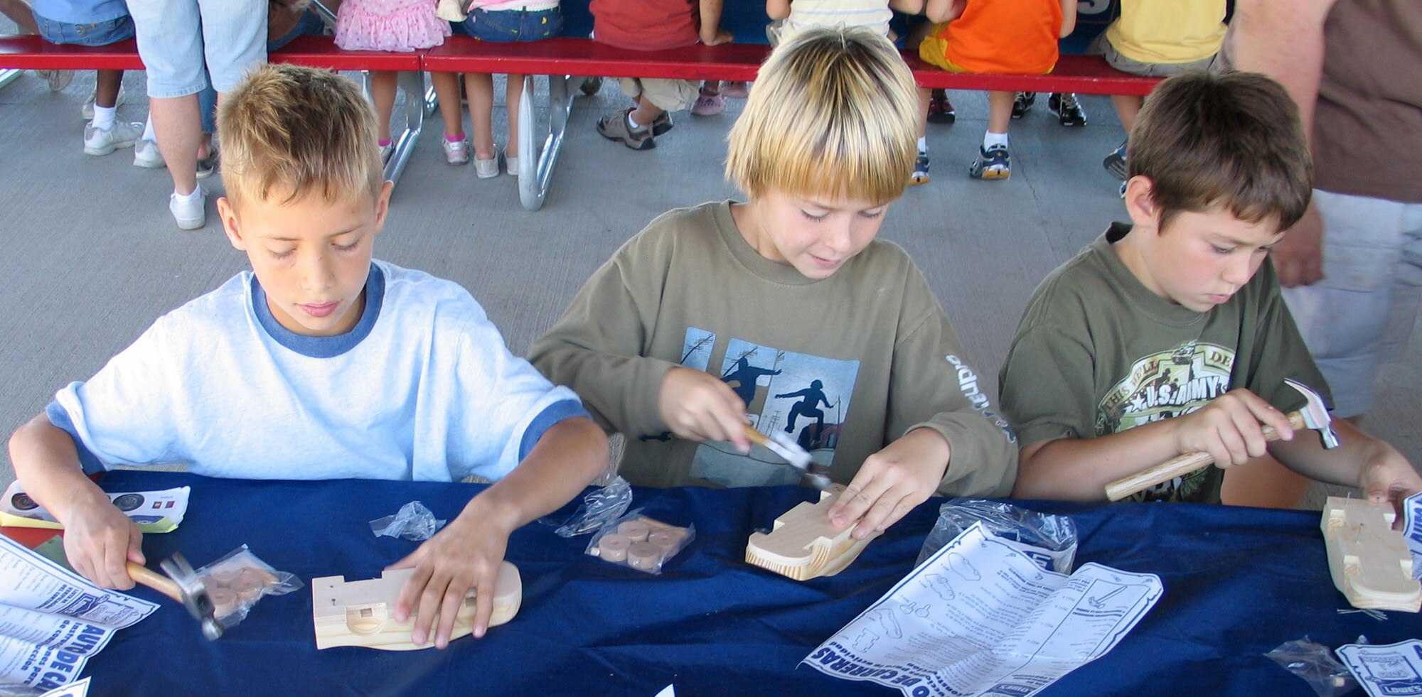 FAIRCHILD AIR FORCE BASE, Wash. – From left, Michael Bell, 9, Mitchell Meuser, 9, and Bryce Crawford, 8, from the Fairchild Youth Center pound the starting nails into their wooden race cars, which they assembled from kits Aug. 14. Four volunteers from Lowe’s Home Improvement in Spokane Valley, Wash., presented the kit-building clinic to more than 80 children here during their Summer Youth Program. (U.S. Air Force photo / Staff Sgt. Connie L. Bias)