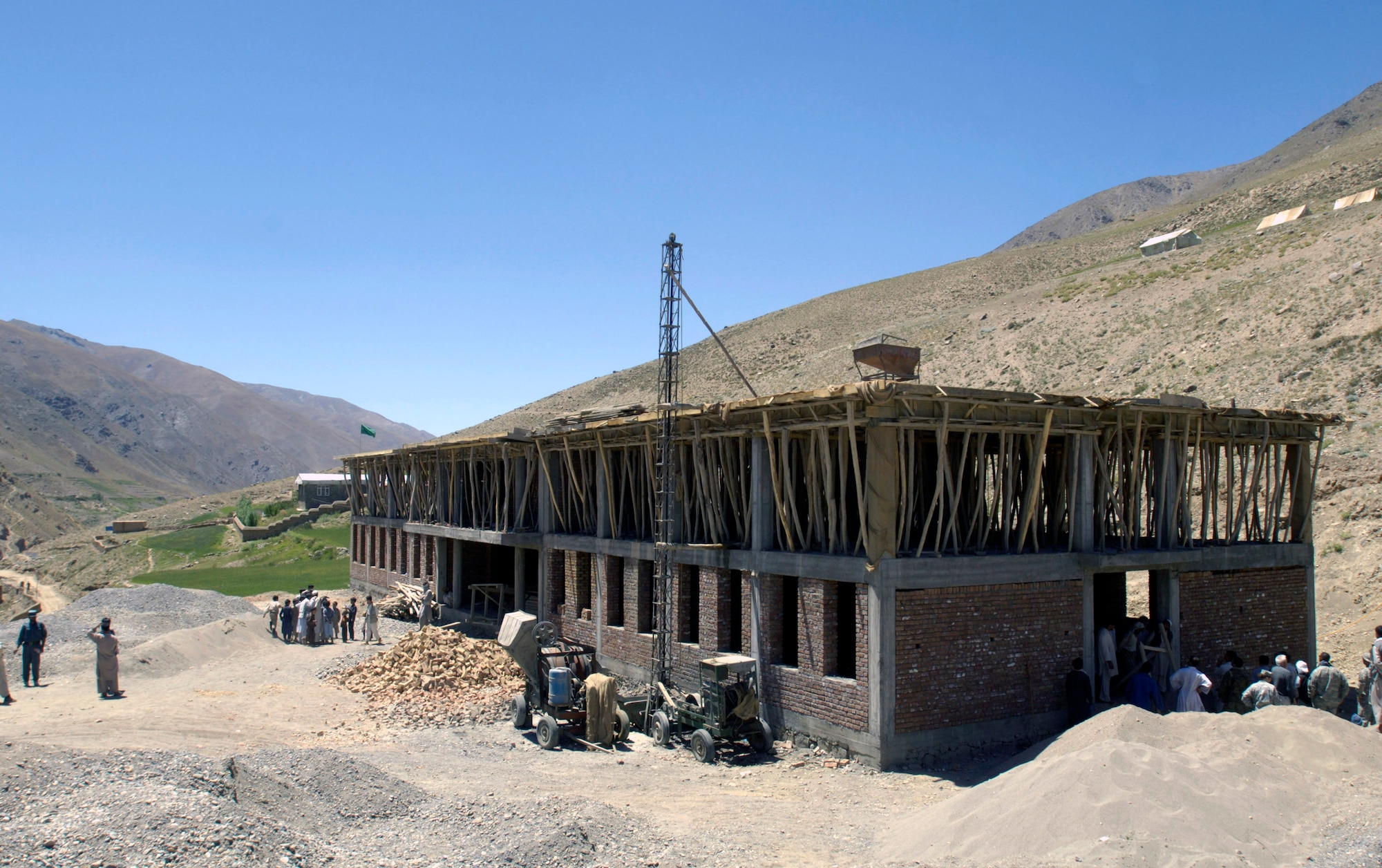 Members of the Panjshir Provincial Reconstruction Team check on the progress of a school construction project Aug. 4 in the Paryan district of Panjshir Province, Afghanistan.  Once completed, the school will accommodate children from several villages in the province. The children are currently attending classes in makeshift tents overlooking the construction site.  The project is one of several being monitored by the PRT.  (U.S. Air Force photo/Master Sgt. Jim Varhegyi)