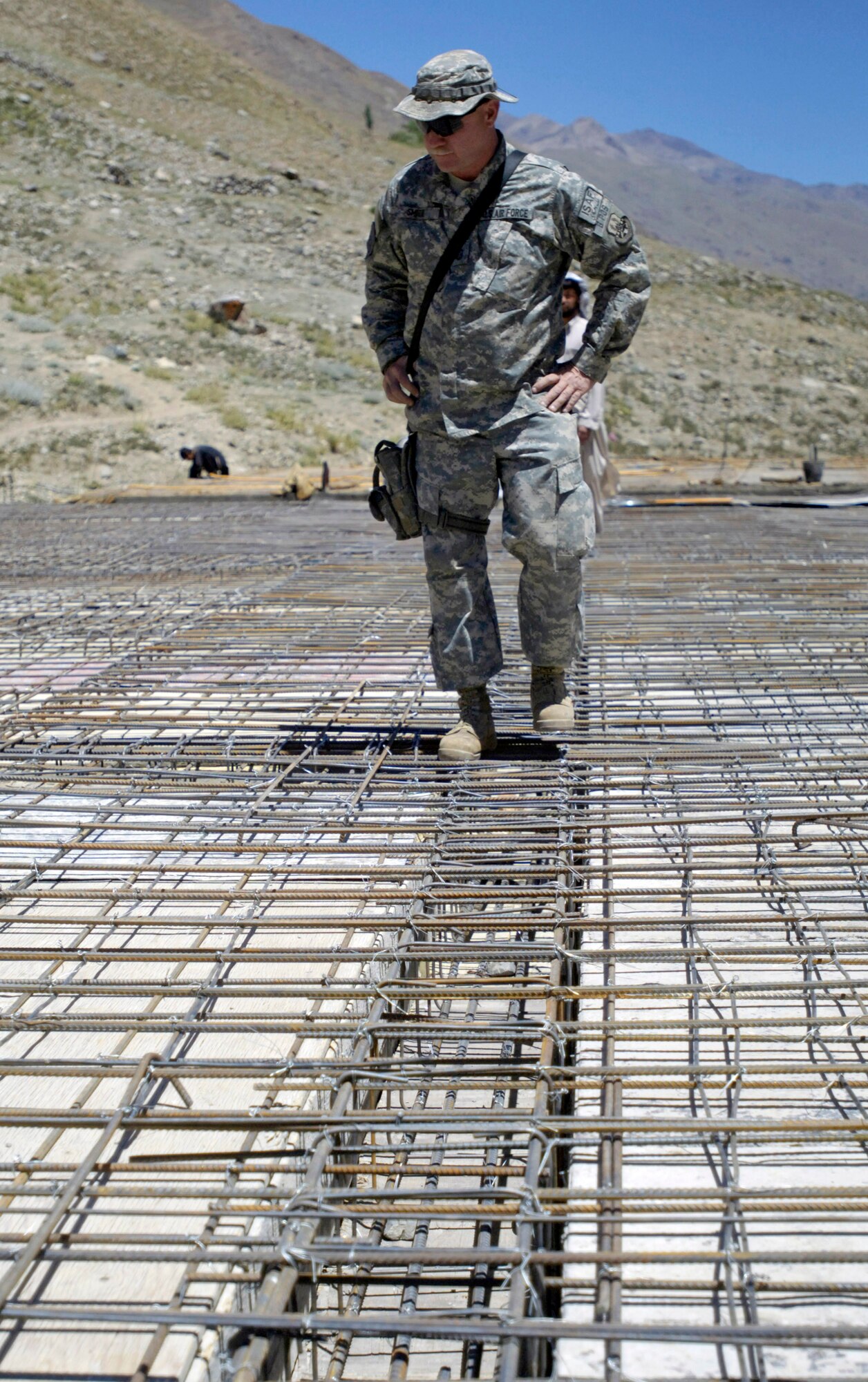 Senior Master Sgt. Roger Smith looks over the rebar grid Aug. 4 which will reinforce the concrete roof at a school construction project in the Paryan district of Panjshir Province, Afghanistan.  Sergeant Smith, a member of the Panjshir Provincial Reconstruction Team, is deployed from Langley Air Force Base, Va.  Once completed, the school will accommodate children from several villages in the province. (U.S. Air Force photo/Master Sgt. Jim Varhegyi)