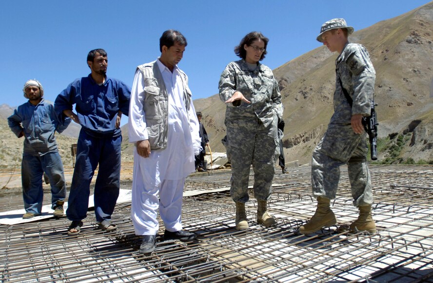 Teresa Morales and 1st Lt. Lee Turcotte discuss the progress of a school construction project with contractors Aug. 4 in the Paryan district of Panjshir Province, Afghanistan.  Ms. Morales, a civil engineer with the U.S. Army Corps of Engineers deployed from Portland, Ore., and Lieutenant Turcotte, a civil engineer from McGuire Air Force Base, N.J., are members of the Panjshir Provincial Reconstruction Team. The school project is one of several being monitored by the PRT. (U.S. Air Force photo/Master Sgt. Jim Varhegyi)  