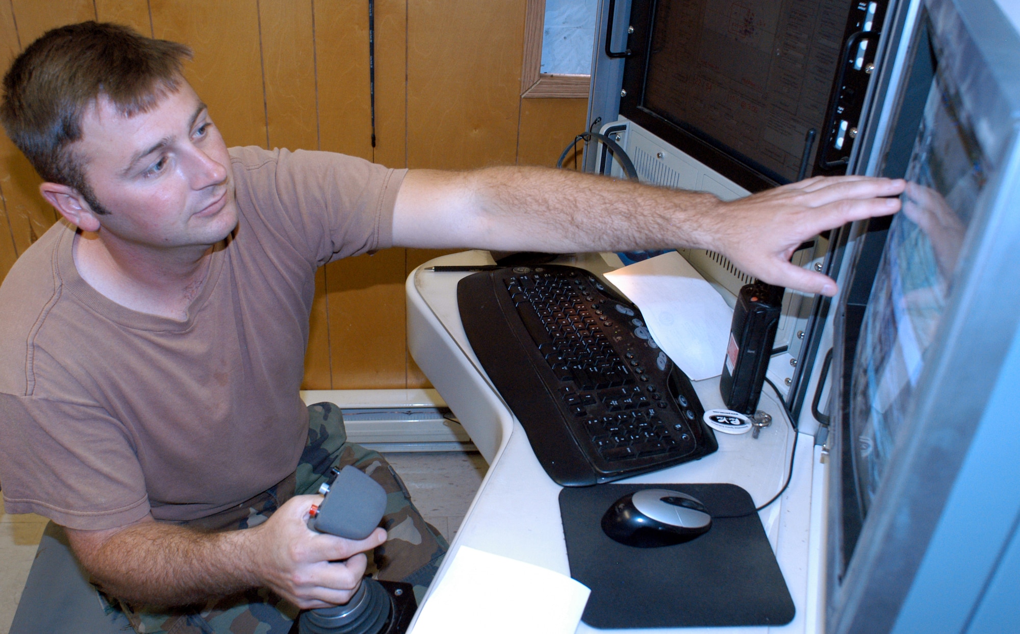 Senior Airman Jared Schomaker operates equipment to record and score hits on various targets in the Cannon Range complex near Fort Leonard Wood, Mo. Airman Schomaker is a communications specialist from the Missouri Air National Guard. Airmen at the range score and record the hits, or misses, from every aircraft that drops a bomb or fires a round onto the range, then relay those scores to the pilots above. (U.S. Air Force photo/Maj. David Kurle) 