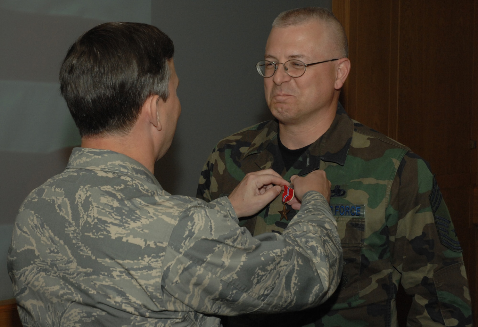 Liberty Wing Command Chief Jeffery Williams is presented with the Bronze Star medal by Brig. Gen. John Hesterman III, during wing stand up Aug 7. Chief Williams received the medal for his actions while serving as the 455th Expeditionary Maintenance Group Superintendent for four months. (U.S. Air Force photo by Airman 1st Class John Easterling)
