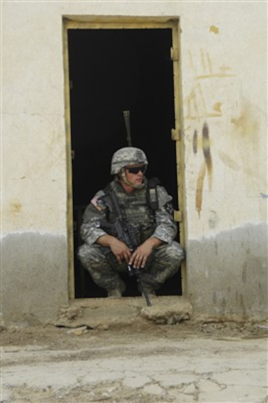 A U.S. Army soldier takes a break in the doorway of a house during a security mission in Baqubah, Iraq, on Aug. 10, 2007.  Soldiers from Charlie Company, 1st Battalion, 23rd Infantry Regiment are conducting operations in the city to capture insurgents and locate weapons caches.  