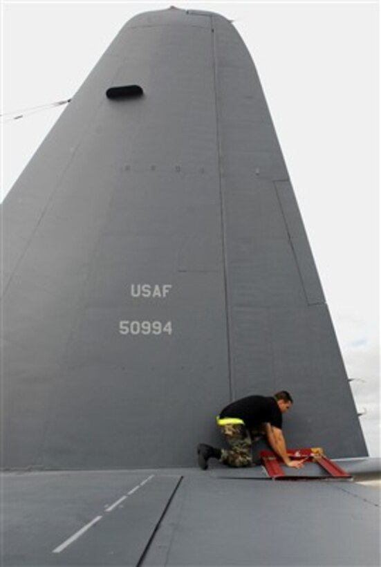 U.S. Air Force Senior Airman Christopher Alfonso removes the gust locks from the tail of a MC-130P Combat Shadow aircraft prior to a mission from Kadena Air Base, Japan, on Aug. 14, 2007.   The locks secure the elevator trim tabs from moving in the wind.  Alfonso is assigned to the 353rd Maintenance Squadron.  