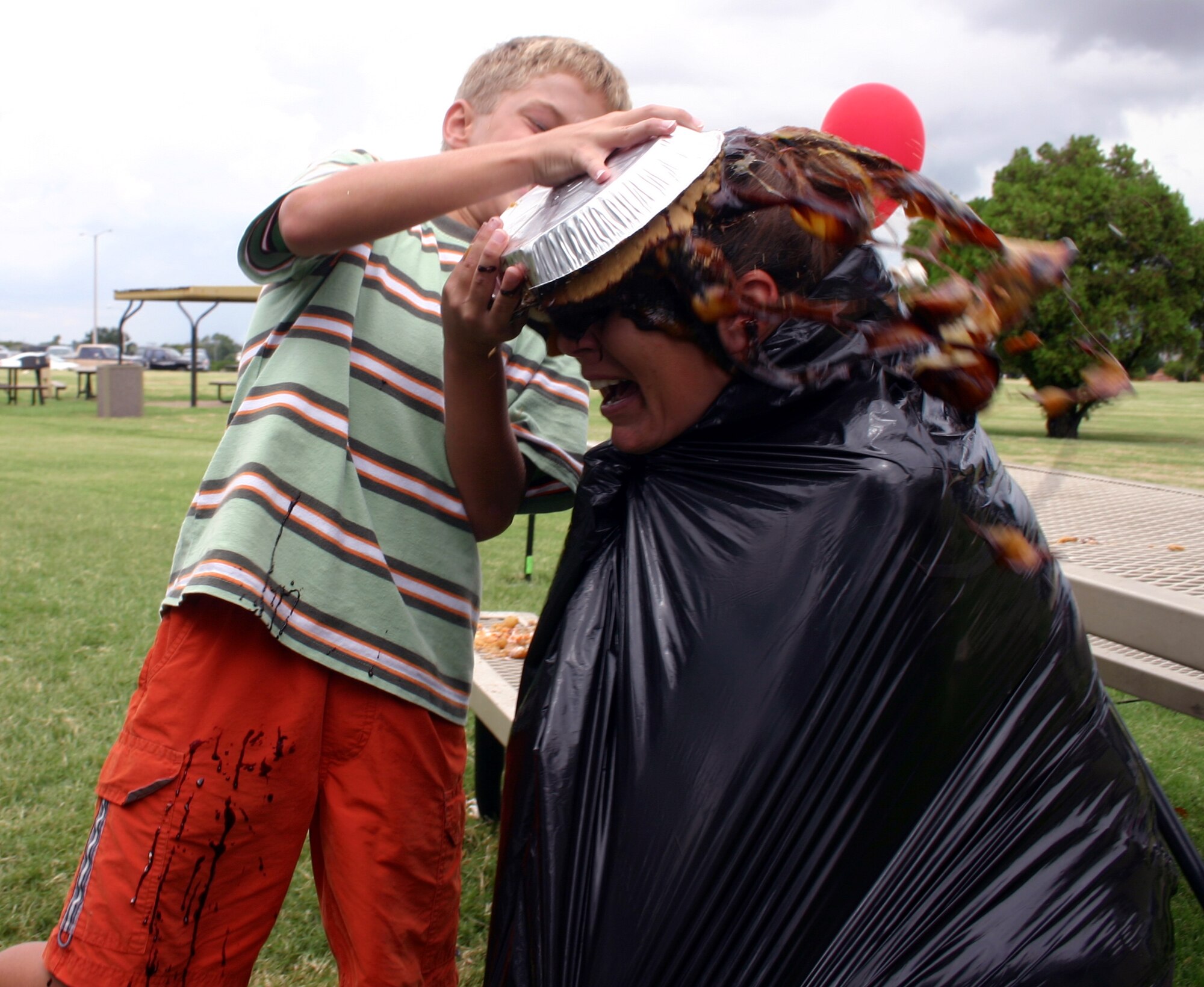 Kim Hervey, 82nd Comptroller Squadron, receives an enthusiastic pie from coworker Ingela Roth's son George at the Enlisted Appreciation Day cookout Aug. 17. (U.S. Air Force photo/Staff Sgt. Tonnette Thompson)