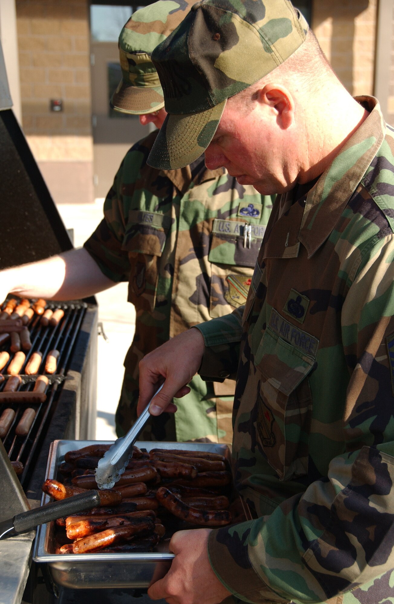 EIELSON AIR FORCE BASE, Alaska -- Master Sgt. Scott Watson, 354th Aircraft Maintenance Squadron first sergeant, places the barbequed hotdogs into a platter for the Fighter Wing cook out Aug. 17, 2007. The cookout was held to show appreciation for all the hard work the Iceman team does year round and also for Brig. Gen. Dave Scott, 354th Fighter Wing commander, to show his thanks to all of the airmen of the 354th Fighter Wing.  (U.S. Air Force photo by Airman 1st Class Christopher Griffin)