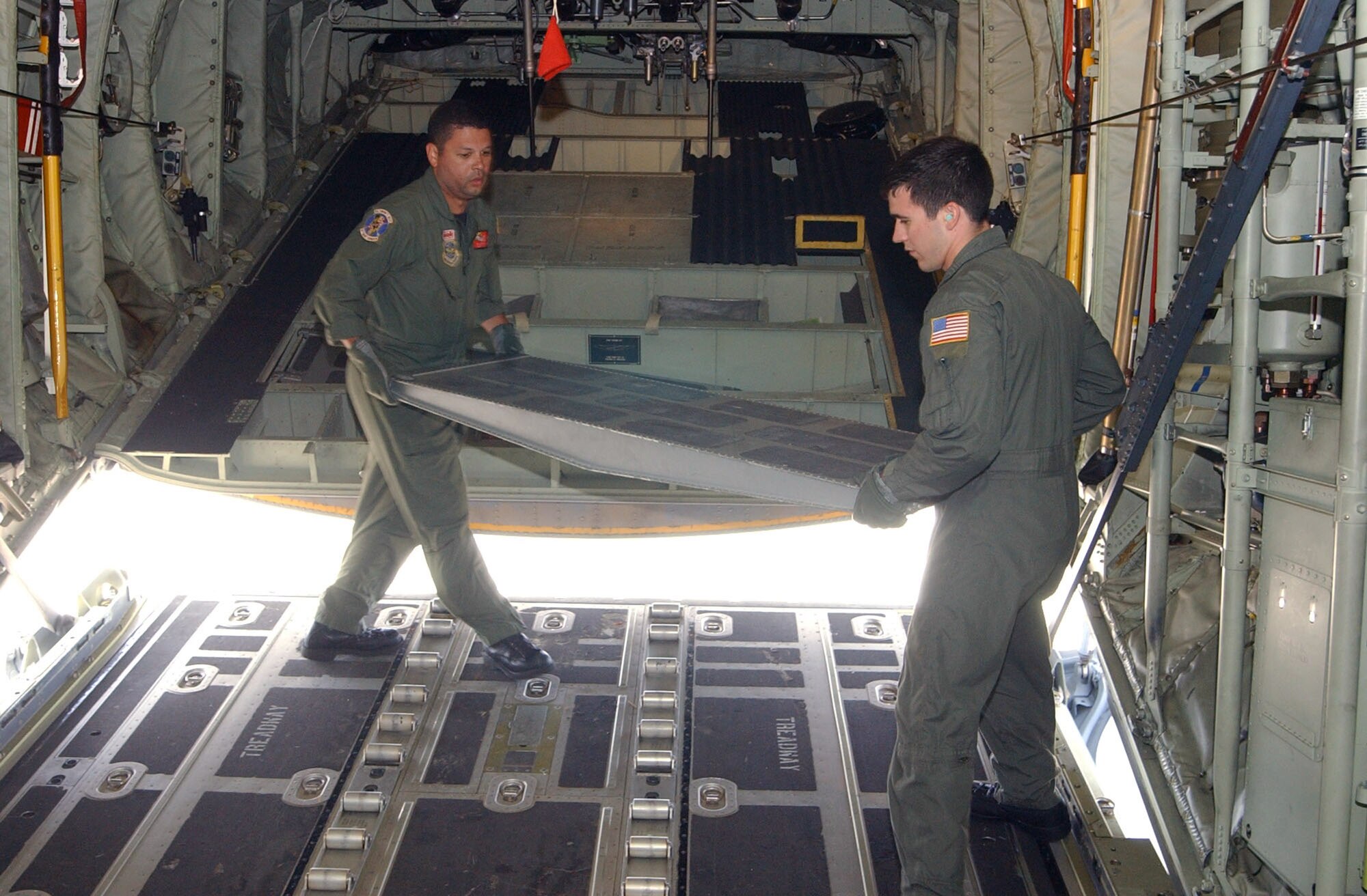 Tech. Sgt. Will Morales (left) and Senior Airman Brandon Krantz configure the interior of a C-130 Hercules Aug. 17 at Soto Cano Air Base, Honduras, before taking off on a relief mission to Peru. Approximately 30 Soldiers and Airmen are responding to the Aug. 15 earthquake in Peru and are taking 4,470 pounds of medical supplies for relief efforts.  Sergeant Morales and Airman Krantz are loadmasters with the Maryland Air National Guard's 135th Airlift Squadron. (U.S. Air Force photo/Tech. Sgt. Sonny Cohrs) 