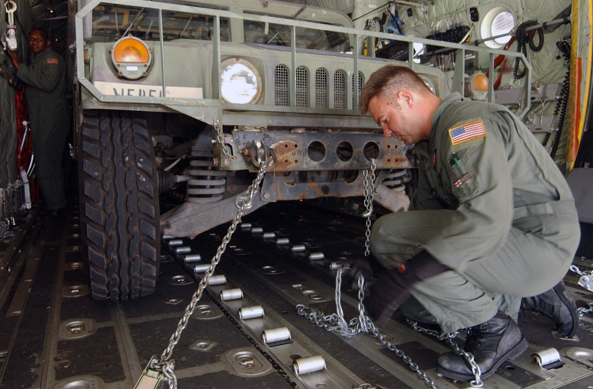 Tech. Sgt. Edward Slavin secures a Humvee inside a C-130 Hercules Aug. 17 at Soto Cano Air Base, Honduras. The Humvee is being deployed to Peru along with a mobile surgical team from Soto Cano. Approximately 30 Soldiers and Airmen are responding to the Aug. 15 earthquake in Peru and are taking 4,470 pounds of medical supplies for relief efforts.  Sergeant Slavin is a crew chief with the Maryland Air National Guard's 135th Airlift Squadron. (U.S. Air Force photo/Tech. Sgt. Sonny Cohrs) 