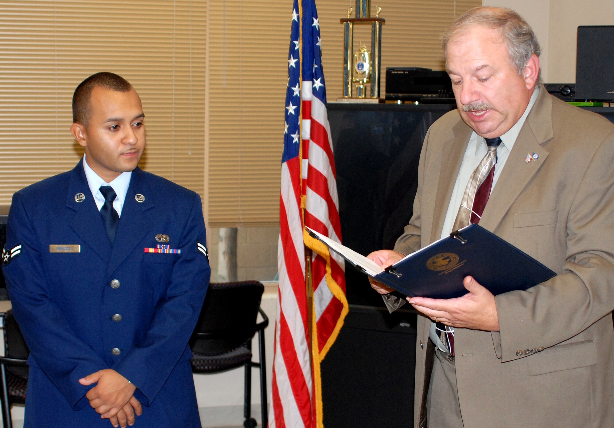 Peter Rechkemmer, Department of Citizenship, Homeland Security, reads the letter which authorizes Airman 1st Class Alex Mendoza, 58th Operations Support Squadron, to take the Oath of Citizenship. U.S. Air Force photo by Dennis L. Carlson