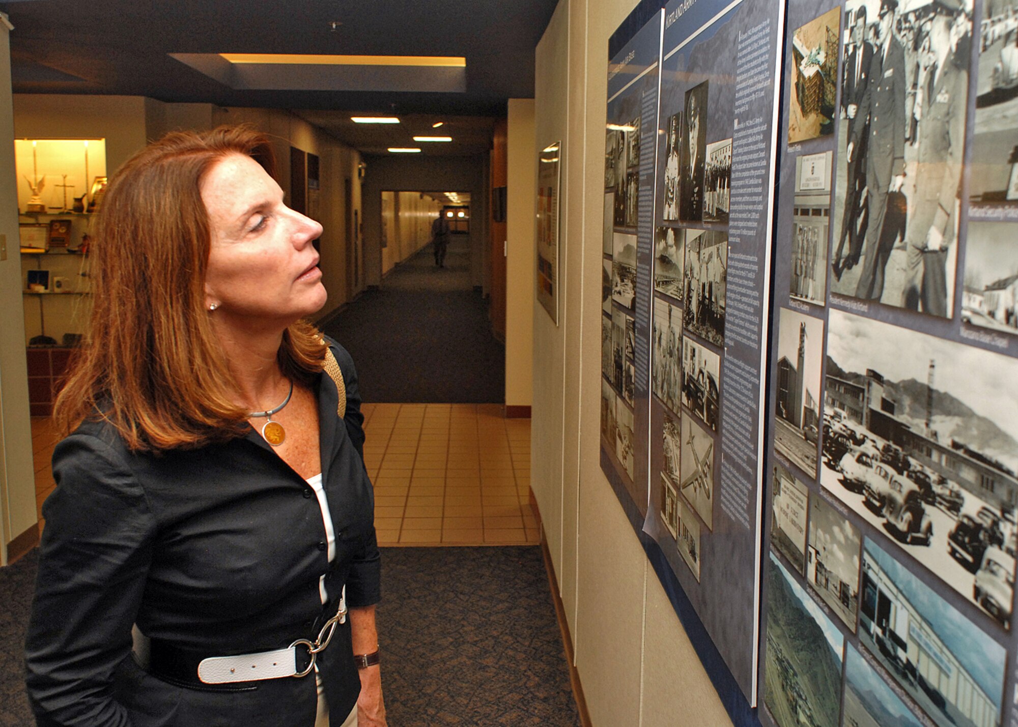 Carter Reynolds, the granddaughter of Col. Roy Kirtland takes a look at the history display in the hallway of the 377th Air Base Wing headquarters during her visit Aug. 9. She also met with Col. Robert E. Suminsby Jr., 377th Air Base Wing commander. Kirtland AFB was named after Colonel Kirtland, one of the military?s early aviators and a proponent of air power. U.S. Air Force photo by Todd Berenger