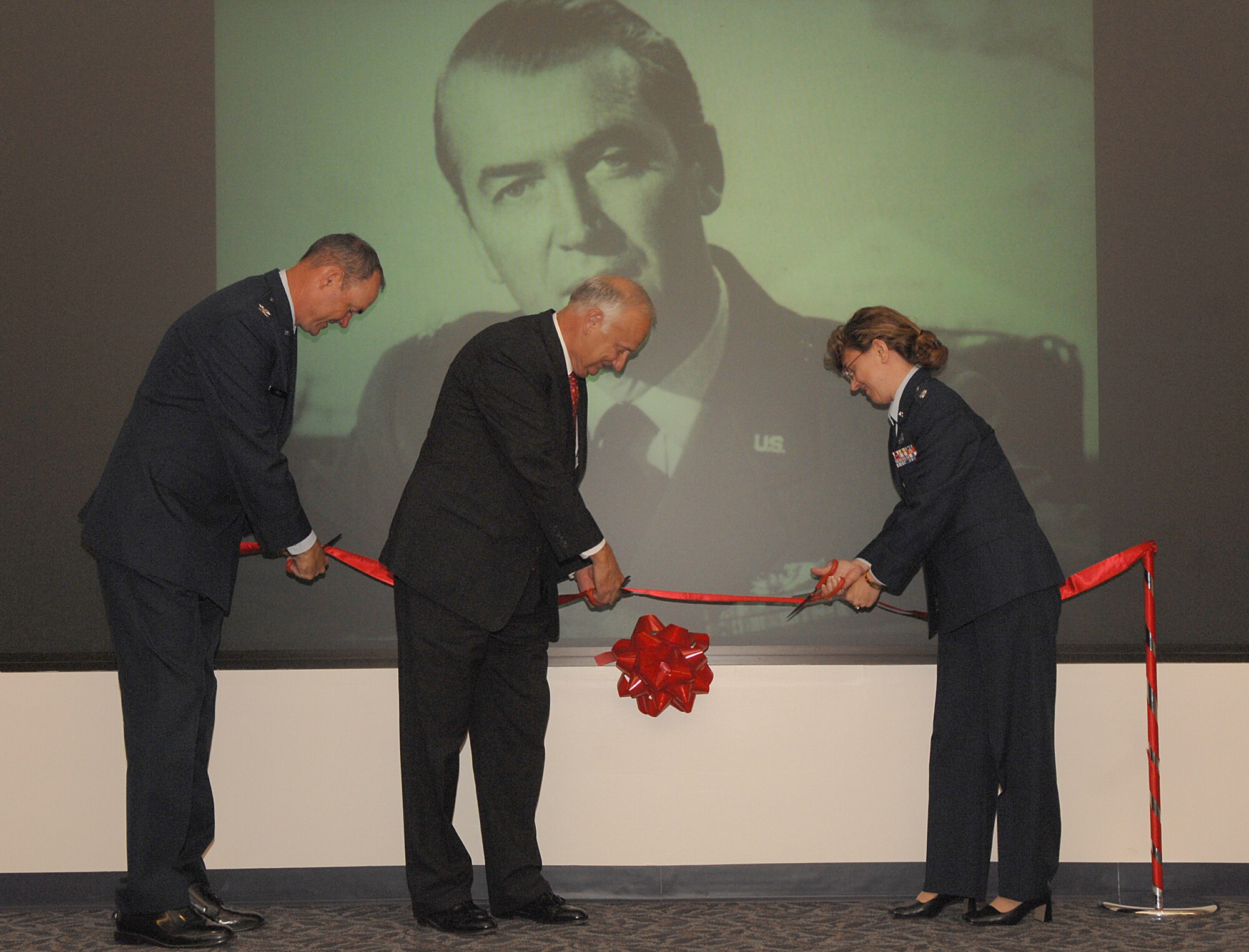 Col. Terry L. Ross (left), 11th Wing vice commander, Carson Green, president of the Jimmy Maitland Stewart Museum and Lt. Col. Diane Jones, 11th Mission Support Squadron commander, cut the ribbon at the Jimmy Stewart Theater dedication ceremony at Building 52 on Bolling Aug. 13. The theater is named after Brig. Gen. James Stewart who enlisted in the Army Air Corps in 1941 and rose to the rank of colonel in four years. At the time of his enlistment Mr. Stewart was a famous actor with an Academy Award to his name. (U. S. Air Force photo by Airman First Class Tim Chacon)