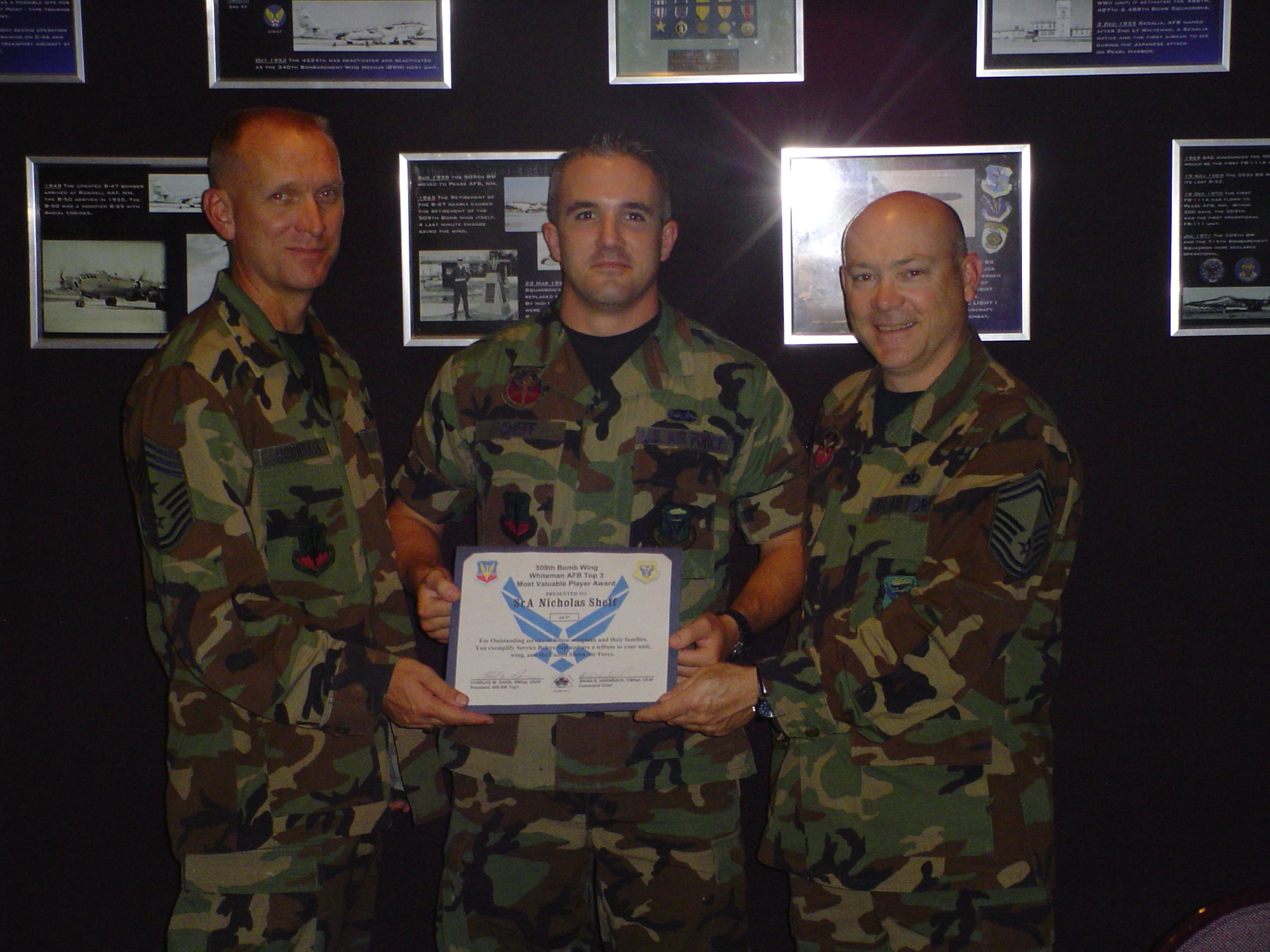 WHITEMAN AIR FORCE BASE Mo. - Left to right: Chief Master Sgt. Brian Hornback, 509th Bomb Wing command chief, Senior Airman Nicholas Sheff, 509th Maintenance Squadron, and Senior Master Sgt. Bill Davis, 509th MXS and Top 3 president, present the Whiteman Top 3 Association Most Valuable Player Award to Airman Sheff Aug. 16.  Airman Sheff  was instrumental in repairing a $6-million test station and obtained permission to complete five depot-level repairs. He also had two technical order changes approved saving the Air Force $500,000 per year. He volunteered for a deployment to Qatar to prevent his peers from leaving their families over the holidays, manages the flight's safety and security programs and was the first avionics test station and components apprentice at Whiteman to be upgraded to his 5-skill level in less than 12 months. The Top 3 MVP award is given each month to any staff sergeant or below throughout the wing. This is the Top 3's way to formally recognize an enlisted individual who epitomizes mission accomplishment, teamwork and esprit de corps for the men and women of the 509th Bomb Wing. (U.S. Air Force photo/Master Sgt. Brett Cousino)


