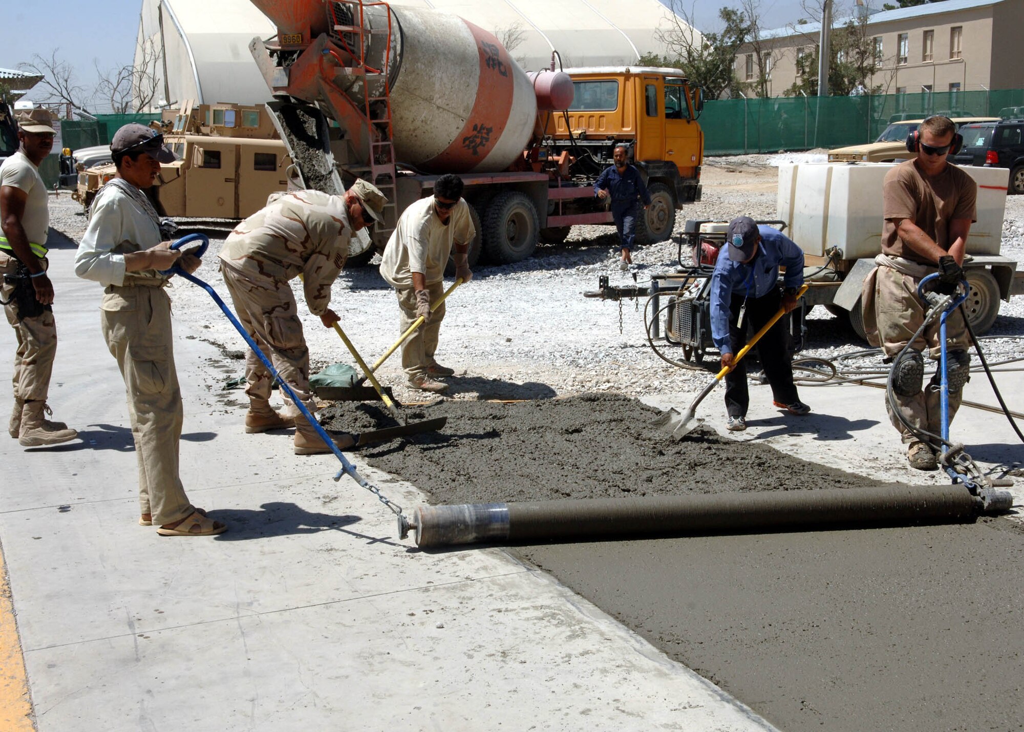 BAGRAM AIRFIELD, Afghanistan -- Airmen from the 455th Expeditionary Civil Engineer Squadron pour and spread concrete to expand the base of the flagpole in Camp Cunningham. (U.S. Air Force photo by Staff Sgt. Craig Seals)
