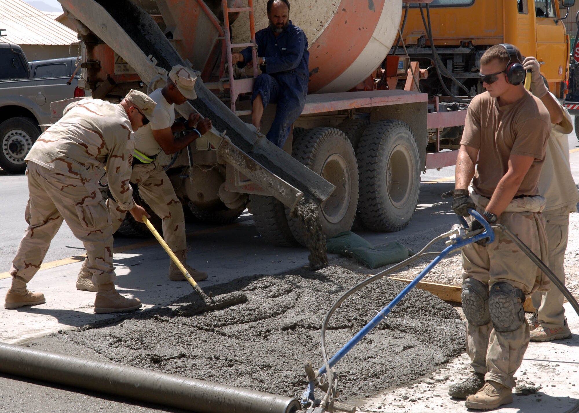 BAGRAM AIRFIELD, Afghanistan -- Airmen from the 455th Expeditionary Civil Engineer Squadron pour and spread concrete to expand the base of the flagpole in Camp Cunningham. (U.S. Air Force photo by Staff Sgt. Craig Seals)