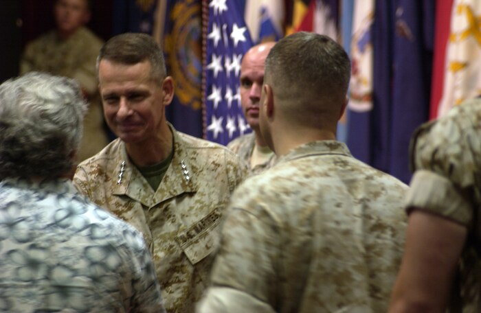 General Peter Pace, chairman of the Joint Chiefs of Staff, presents Bo Irvine, base safety, with a challenge coin Aug. 17, at the base theater. Pace spoke to service members and Department of Defense employees aboard the base to thank them for their service to their country.