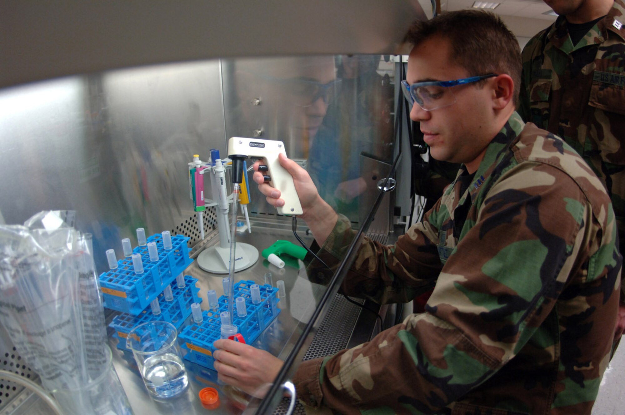 Cadet 1st Class Brandon Martinez transfers bacteria from jet fuel into culture tubes in a laboratory at the U.S. Air Force Academy in Colorado Springs, Colo. The bacteria eat jet fuel and produce a slime that can foul jet engines. Academy cadets perform this research as part of their curriculum. (U.S. Air Force photo/John Van Winkle)