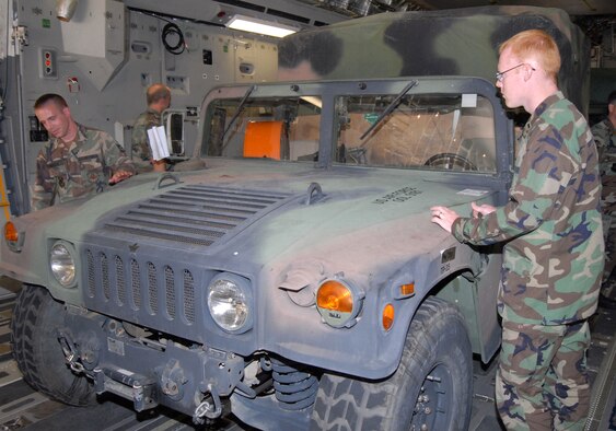 Staff Sgt. Phil Benson (left) and 1st Lt.. Joseph Popham check out their vehicle after it was loaded onto a C-17 Globemaster III headed for Brownsville, Texas, Aug. 19 at Pope Air Force Base, N.C. The Airmen are members of Pope AFB's 43rd Aeromedical Evacuation Squadron who deployed to prepare for Hurricane Dean relief efforts. (U.S. Air Force photo/Ed Drohan)