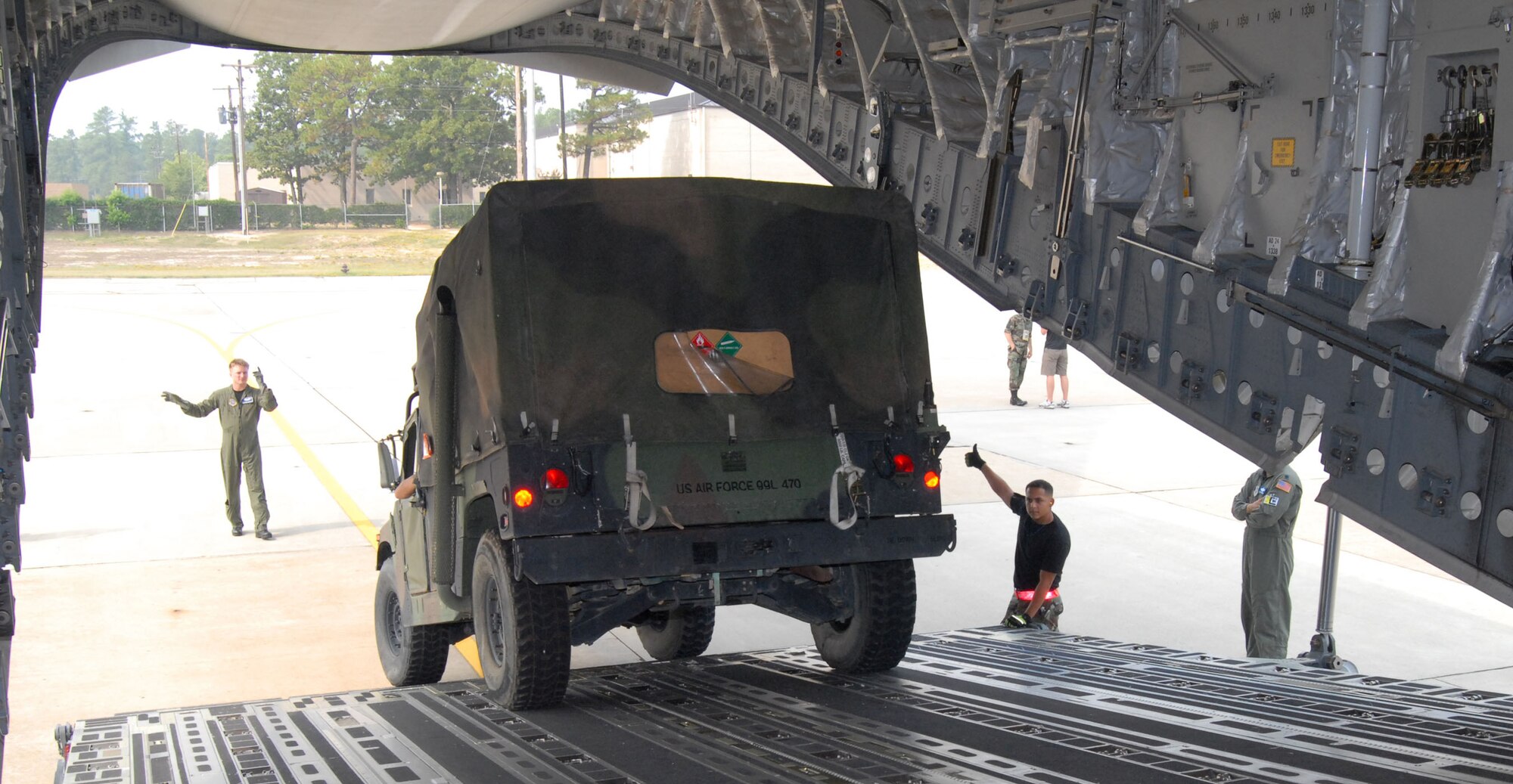 Flight and ground crewmembers work together to load a Humvee onto a C-17 Globemaster III at Pope Air Force Base, N.C., Aug. 19. The vehicle and approximately 40 members of Pope AFB's 43rd Aeromedical Evacuation Squadron deployed to set up a Mobile Aeromedical Staging Facility in Brownsville, Texas, in preparation for the approach of Hurricane Dean. (U.S. Air Force photo/Ed Drohan)