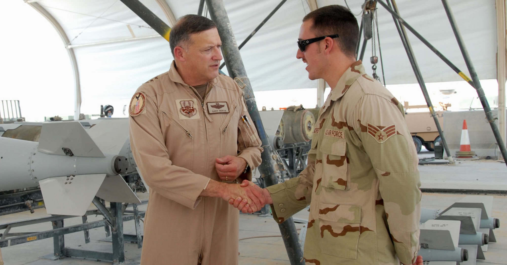 Lt. Gen. Gary North recognizes Senior Airman Michael McAndrew with a coin for his superior work ethic since his unit arrived in Southwest Asia less then a month ago. The general is the commander of U.S. Central Command Air Forces and 9th Air Force. Airman McAndrew is assigned to the 379th Expeditionary Maintenance Squadron munitions flight. (U.S. Air Force photo/Airman 1st Class Ashley Tyler)
