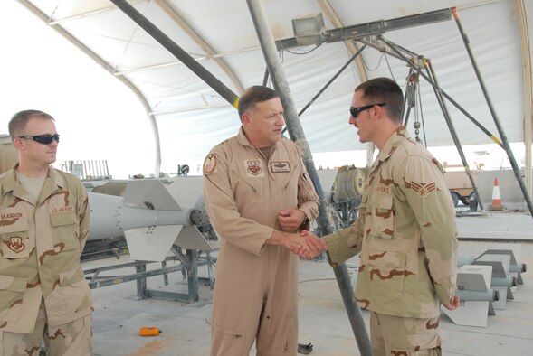 Lt. Gen. Gary North, U.S. Central Command Air Forces commander and 9th Air Force commander, recognizes Senior Airman Michael McAndrew, 379th Expeditionary Maintenance Squadron munitions flight, with a coin for his superior work ethic since the unit arrived here less then a month ago. (U.S. Air Force photo by Airman 1st Class Ashley Tyler)