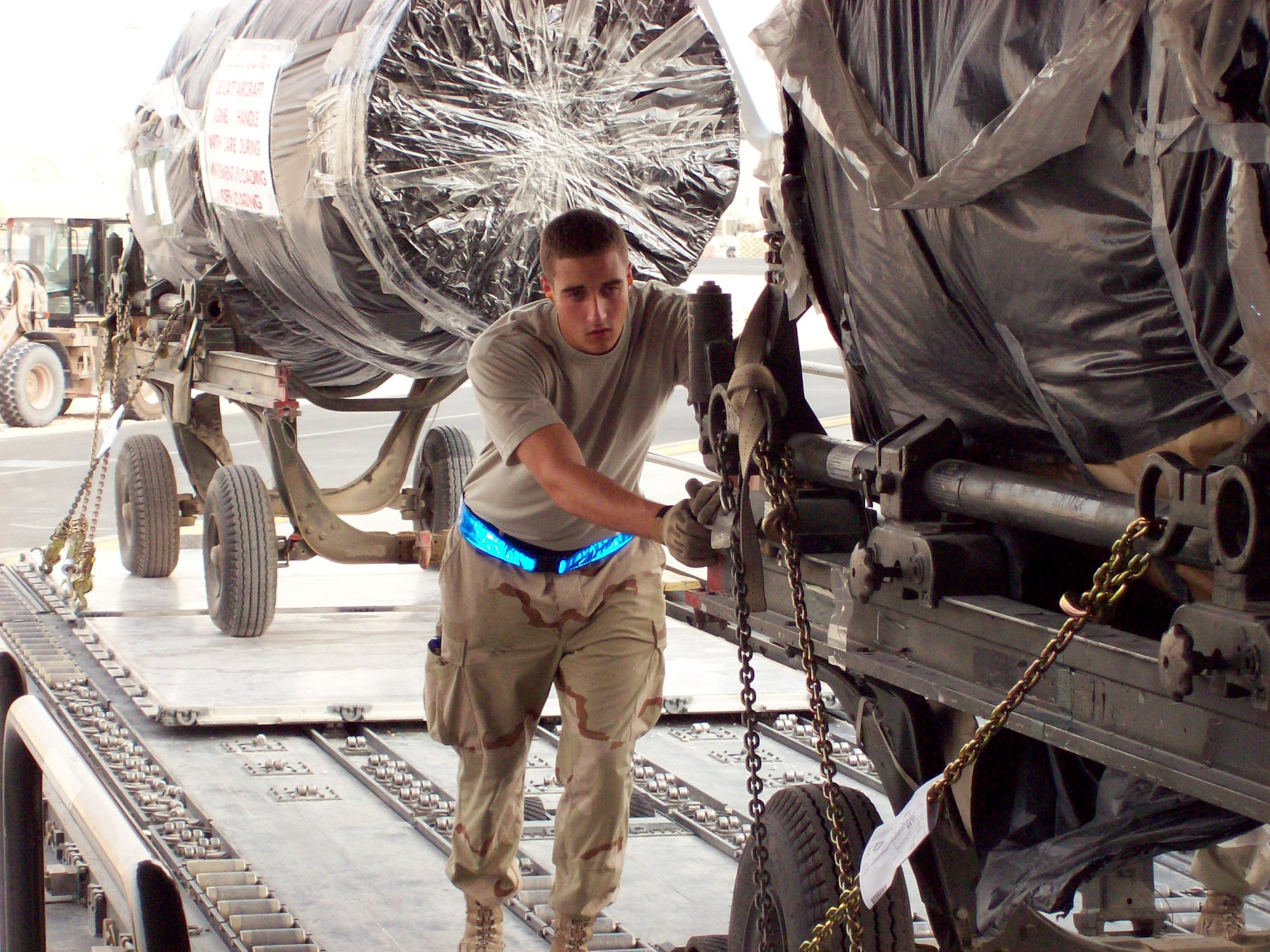 An Airman with the 8th Expeditionary Air Mobility Squadron loads an engine from a K-loader onto a C-17. The 8th EAMS runs the aerial port here, which moves passengers and cargo through the area of responsibility. (U.S. Air Force)