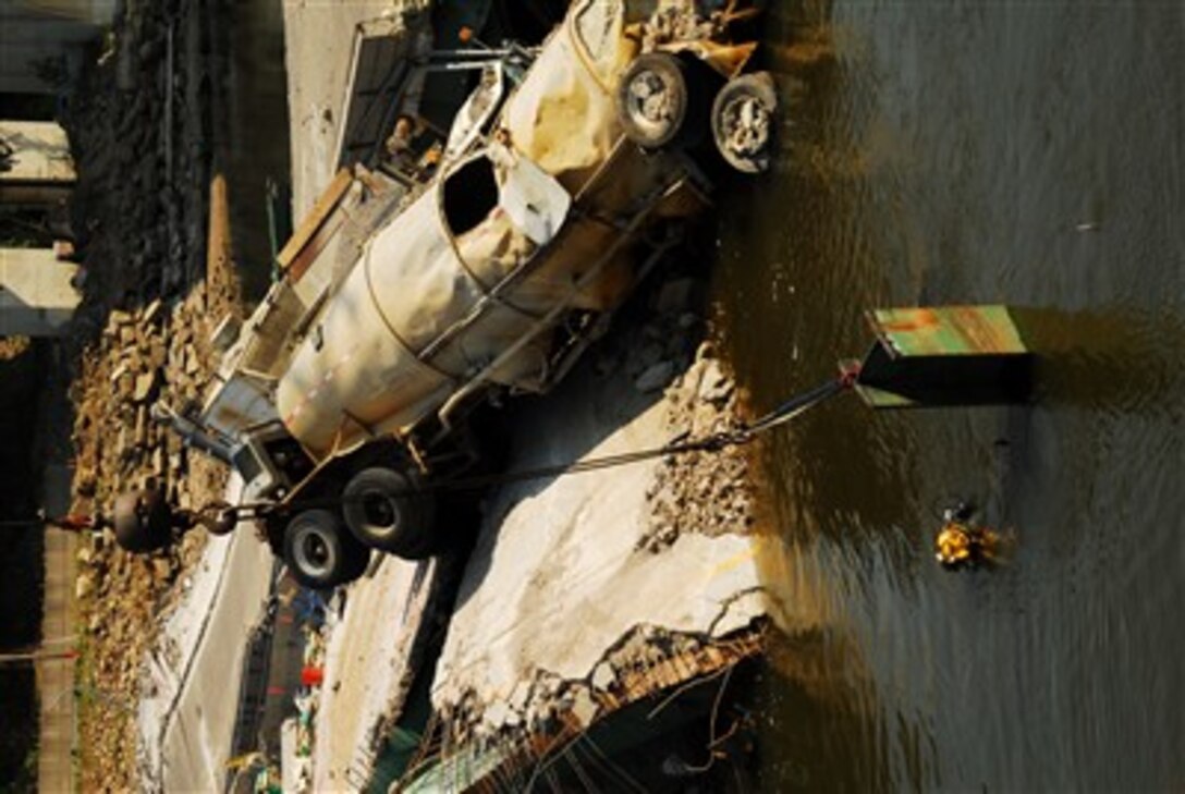 A U.S. Navy diver from Mobile Diving and Salvage Unit 2 from Naval Amphibious Base Little Creek, Va., works on removing debris from the water at the site of the I-35 bridge collapse over the Mississippi River in Minneapolis, Aug. 17, 2007.