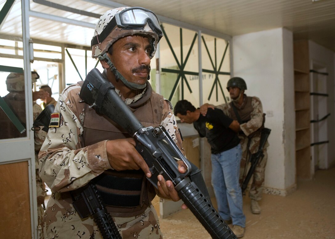 20 August 2007, an Iraqi soldier with 2d Brigade, 7th Iraqi Division provides security in a building being cleared by 2-7 soldiers during a close quarters combat qualification course at Camp Al Asad, Iraq. Marines from 4th Reconnaissance Battalion, 4th Marine Division are working with the Iraqi soldiers to train them in close quarters combat skills. 2d Brigade, 7th Division is with Multi National Forces-West in support of Operation Iraqi Freedom in the Al Anbar province of Iraq to develop Iraqi Security Forces, facilitate the development of official rule of law through democratic reforms, and continue the development of a market based economy centered on Iraqi reconstruction. (Official USMC photograph by Cpl. Shane S. Keller)