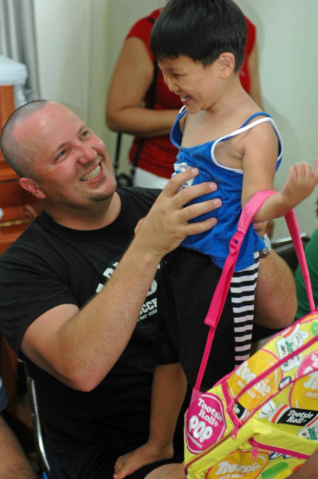 OSAN AIR BASE, Republic of Korea --  Sgt. Michael T. O’Brien laughs with a young boy during the Headquarters and Headquarters Battery, 35th Air Defense Artillery Brigade's visit to the Ae-Hyang Won orphanag Aug. 18. (Photo by Maj. Richard Stebbins)
