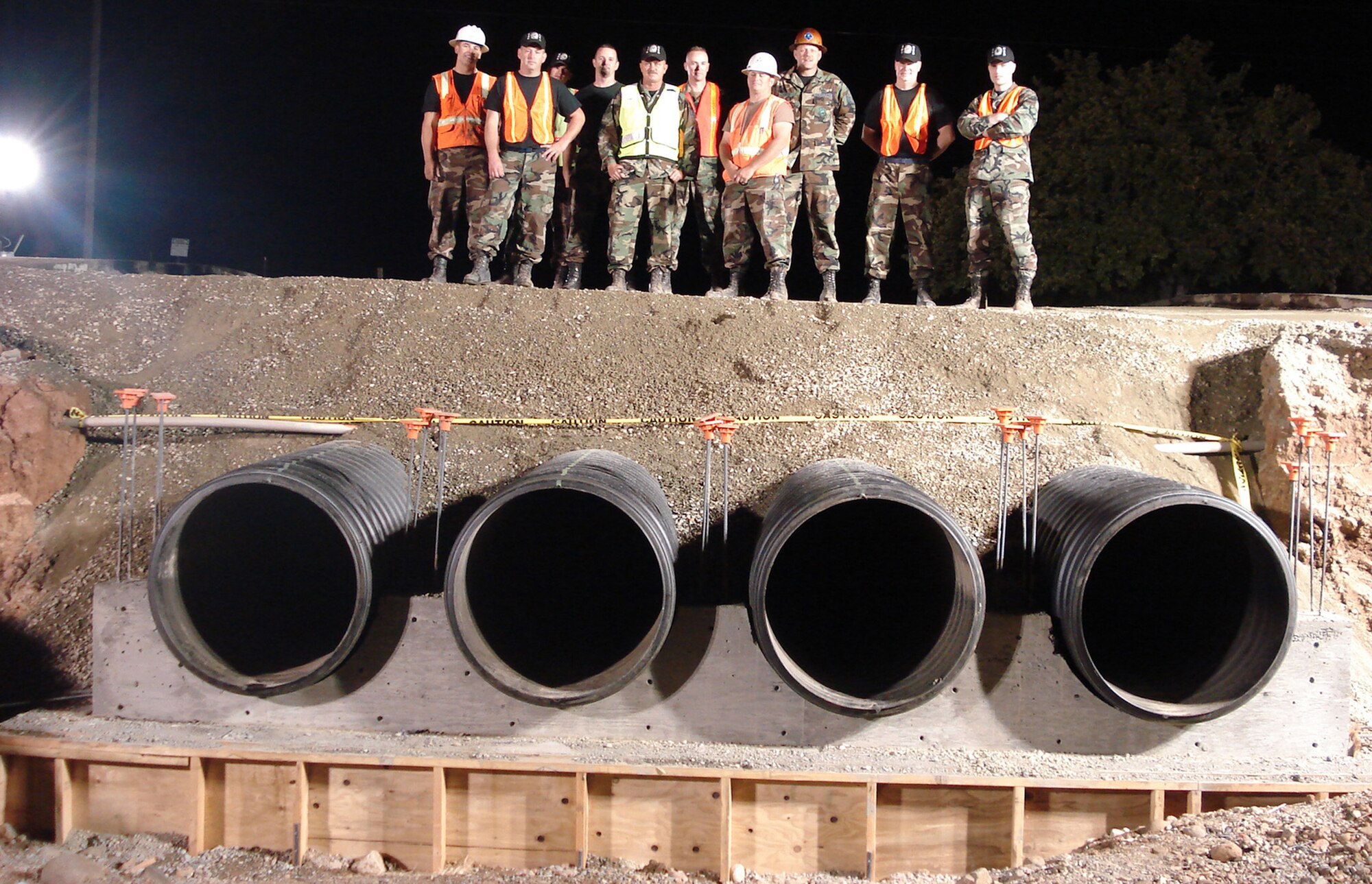 The 940th Civil Engineer Squadron road warriors team looks over all they accomplished Aug. 10, their first night's work on Warren Shingles Road, Beale Air Force Base, Calif. The Reservists teamed up with their active duty counterparts at the 9th CES to replace culverts and repair one of the main roads that had been severely damaged by flooding. From the left: Airman 1st Class Joshua Kerr, Technical Sgt. Don Gruver, Senior Amn Andrew Copeland, Senior Master Sgt. Steve Wichers, Master Sgt. Alan Carlson, SMSgt. Scott Marler, TSgt. Al Fanini, MSgt. Chris Estep, Staff Sgt. Robert Jones and 1st Lt. Jesse Cason. (US Air Force photo/Capt. Ramiro Ramos)                               