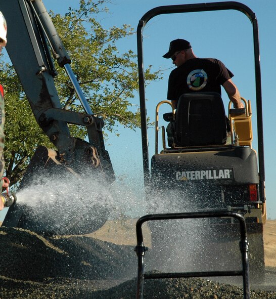 Master Sgt. Chris Estep, 940th Civil Engineer Squadron structural supervisor, mans a roller to tamp down wet gravel into the road bed in preparation for paving. Ten members of the 940th Civil Engineer Squadron, Beale Air Force Base, Calif., teamed up with their active duty counterparts in the 9th CES to work round the clock on a base repair project Aug. 10-13, 2007.  (US Air Force Photo/Master Sgt Ellen L Hatfield)