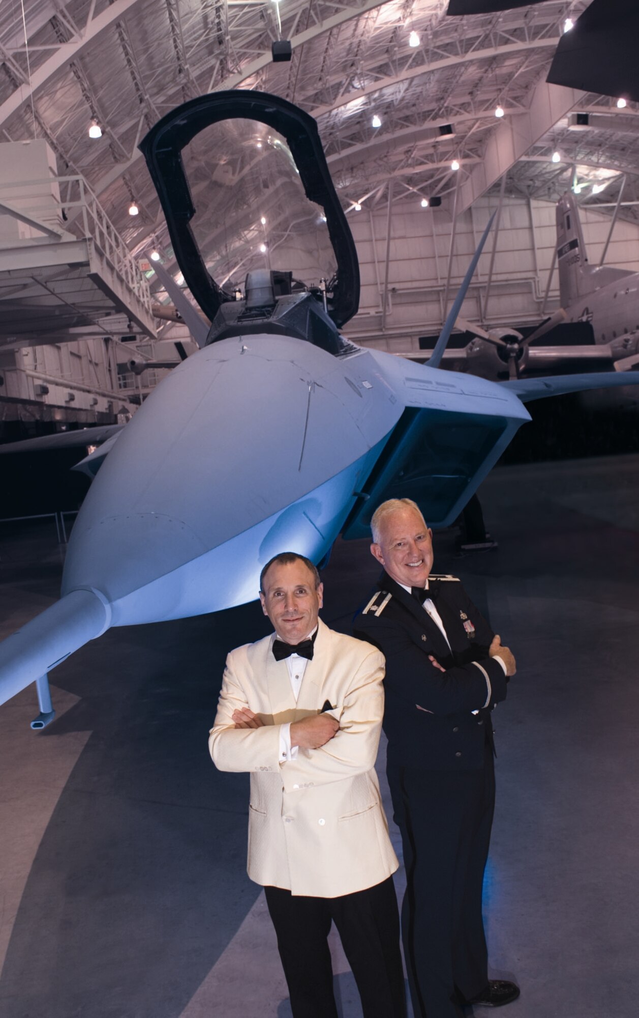 Lt Col Alan Sierichs, commander, USAF Band of Flight and Maestro Neal Gittleman, conductor, Dayton Philhramonic Orchestra, stand in front of the USAF F-22 Raptor at the National Museum of the USAF.