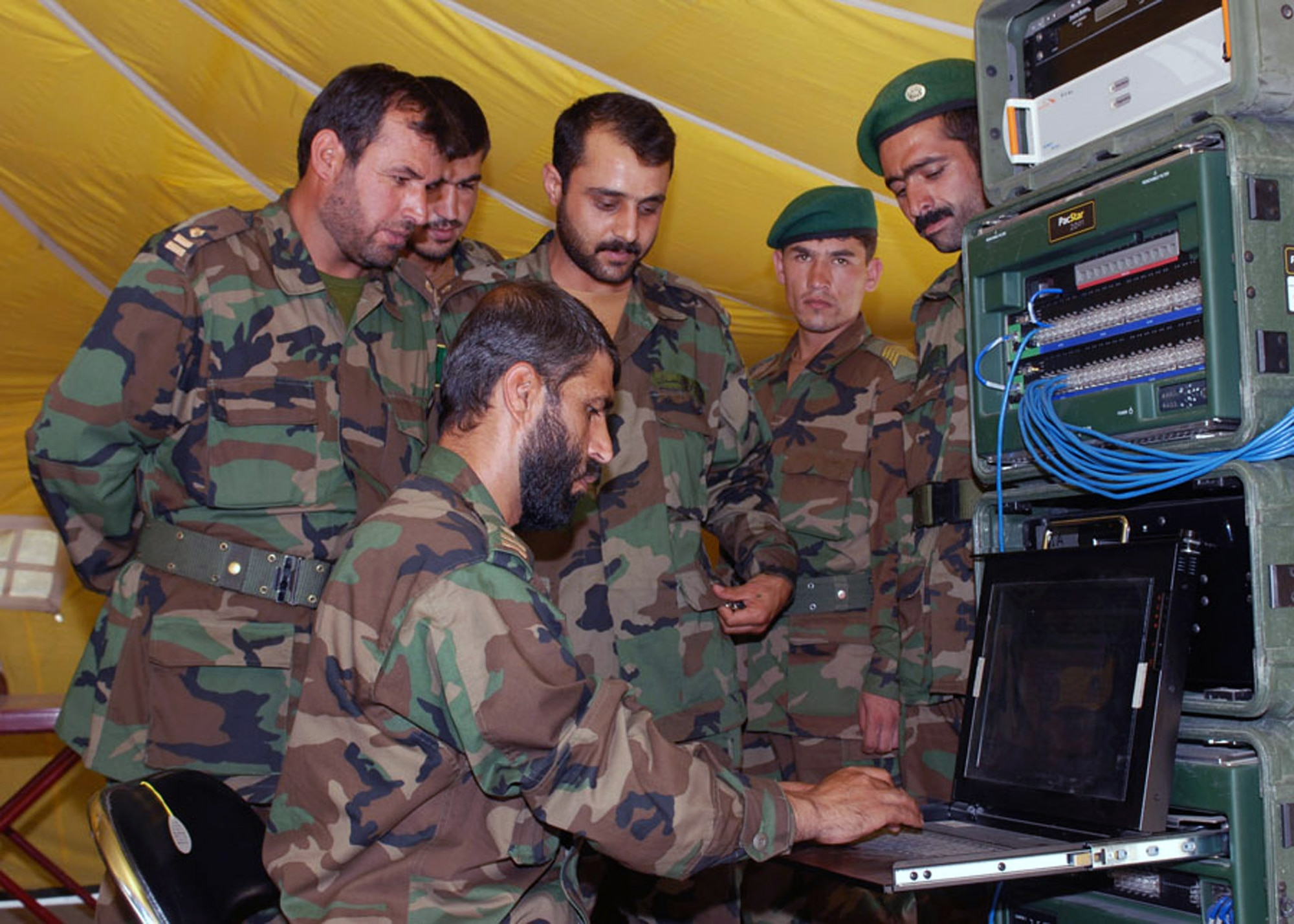 Afghan Capt. Enayatullah of the Afghan National Army demonstrates field communication capability to fellow members of the communications support element in Kabul, Afghanistan. The communications support element is responsible for restoring communications for the ANA. The demonstration was part of the ANA's July 2007 communications conference, which is the first one planned and carried out primarily by the ANA. The purpose of the conference was to plan tactical communications and discuss common issues among corps communications officers. (U.S. Navy photo/Petty Officer 1st Class David M. Votroubek) 
