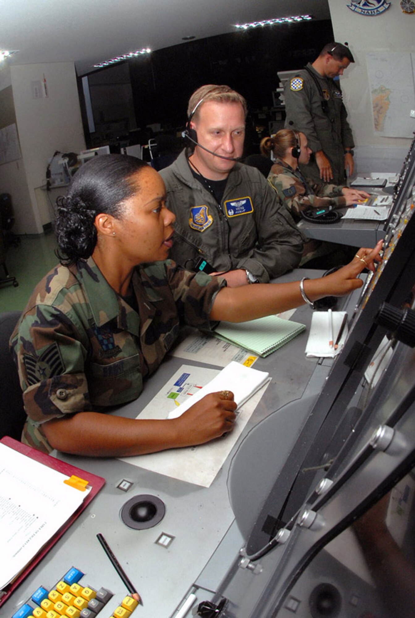 Tech. Sgt. Connie Brent and Maj. Charles Dennison control a large force exercise using the Base Air Defense Ground Environment system at Naha Air Base, Japan. Sergeant Brent relays time-sensitive information to Major Dennison, the mission crew commander, who controls the air space by guiding aircraft into different sections according to the mission plan. They are assigned to the 623rd Air Control Flight. (U.S. Air Force photo/Staff Sgt. Steven Nabor)